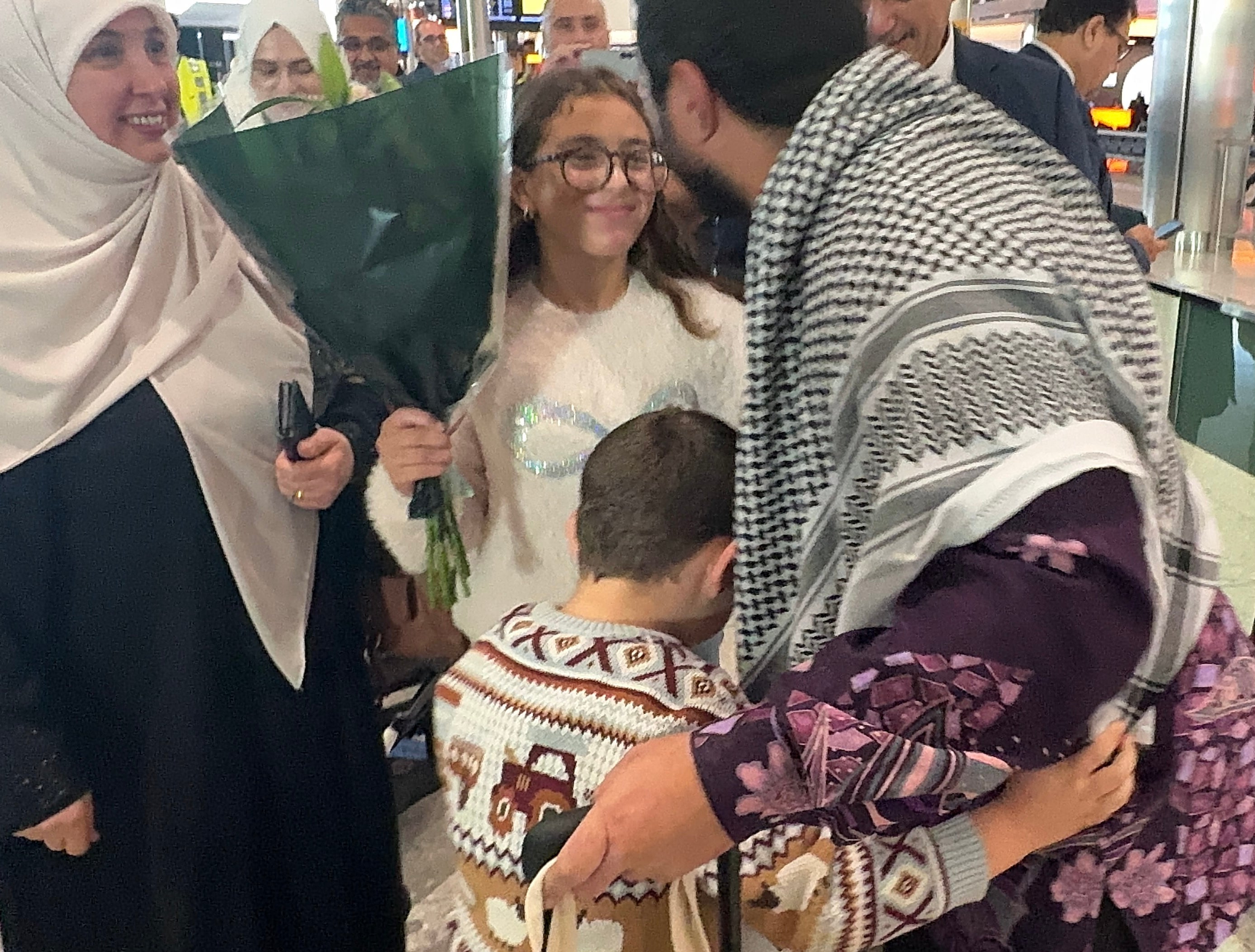 British political commentator Sami Hamdi being greeted by family members at Heathrow Airport upon his return to the UK after he was held by ICE