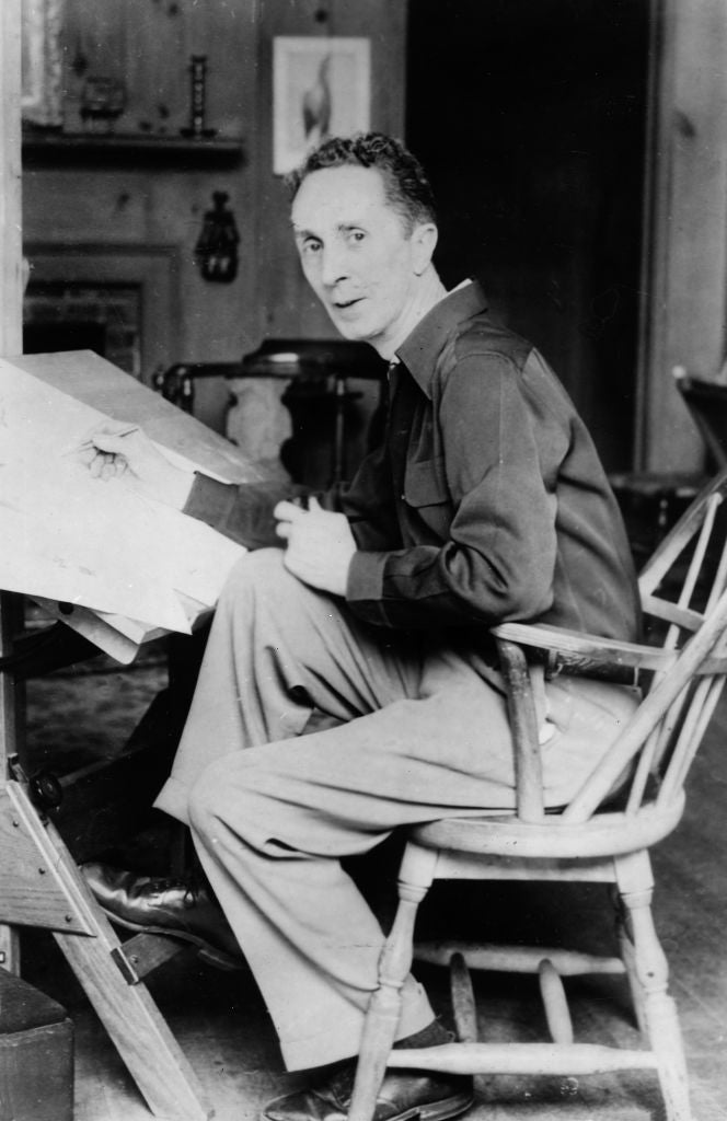 <p>American artist Norman Rockwell (1894 - 1978) looks up while seated at his drawing table, circa 1945</p>