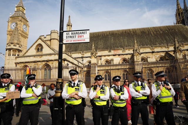 <p>Police officers stand outside the Palace of Westminster as demonstrators take part in a Lift the Ban on Palestine Action protest organised by Defend our Juries in Parliament Square in London.</p>