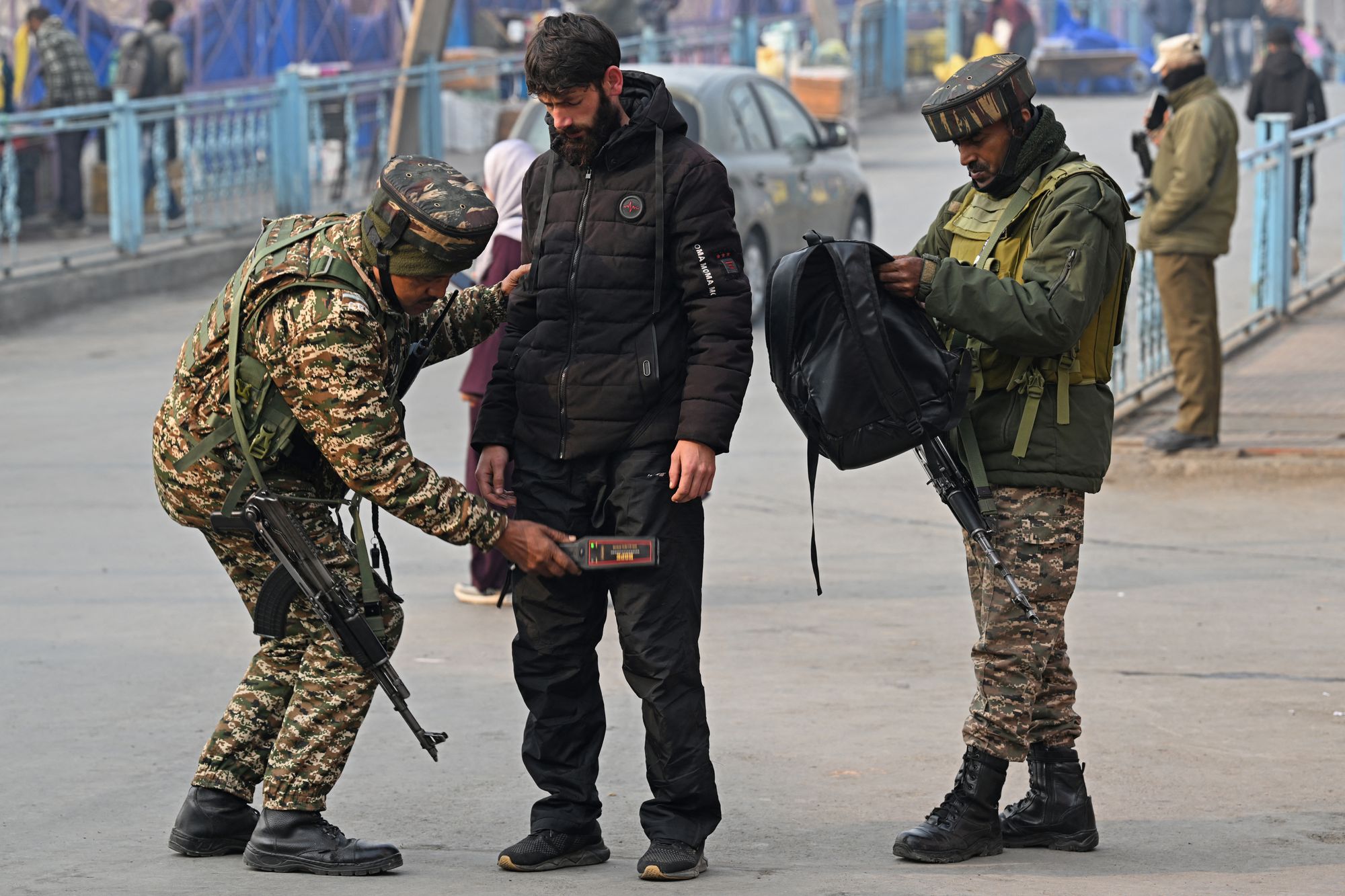 Soldados paramilitares indianos revistam pedestre durante busca aleatória em Srinagar