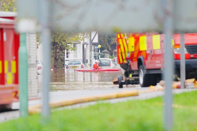 Emergency services in a kayak on Cinderhill Street in Monmouth after heavy rain led to flooding (Ben Birchall/PA)