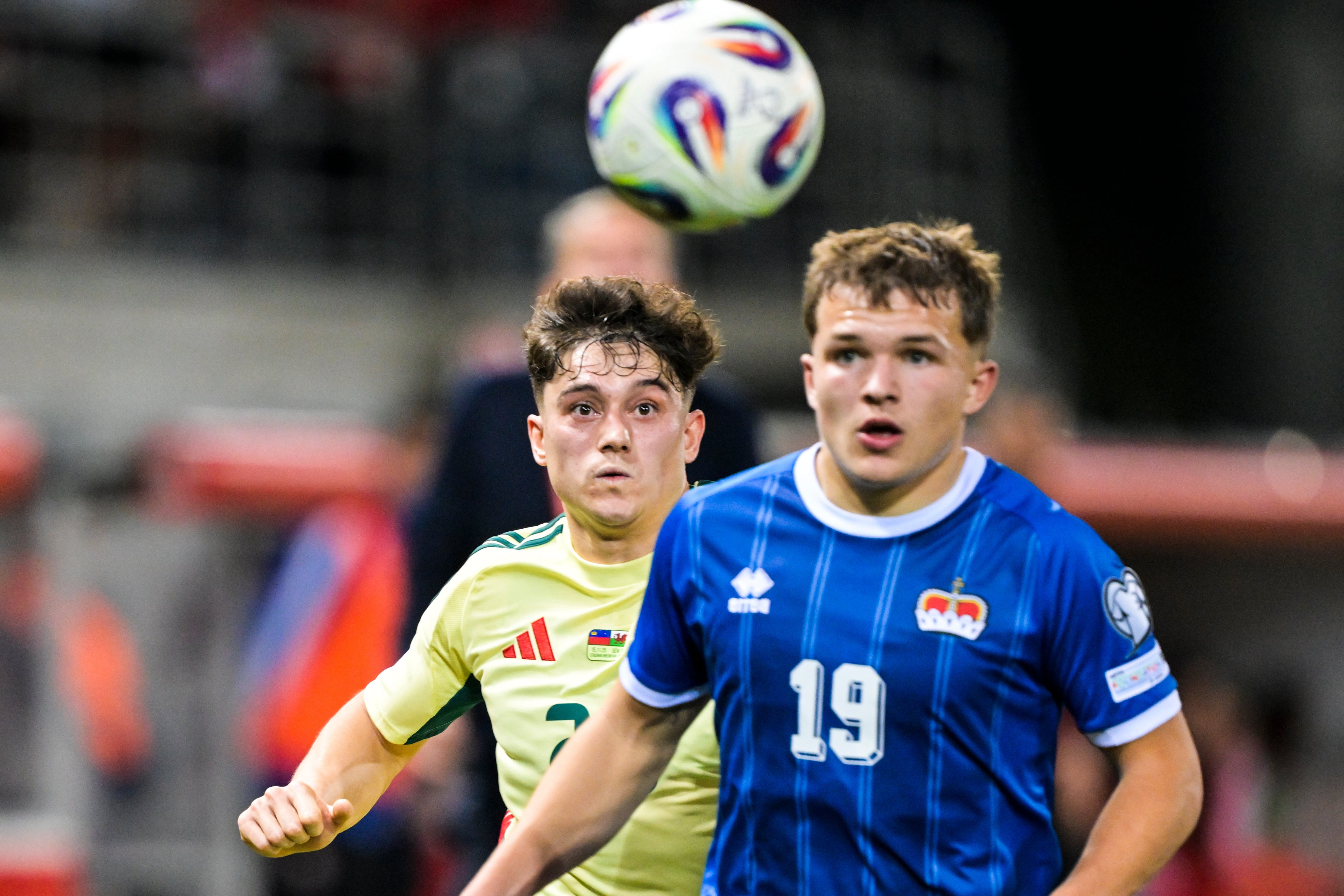 El extremo galés Daniel James (izquierda) y Emanuel Zund de Liechtenstein luchan por el balón (Gian Ehrenzeller/Keystone vía AP)