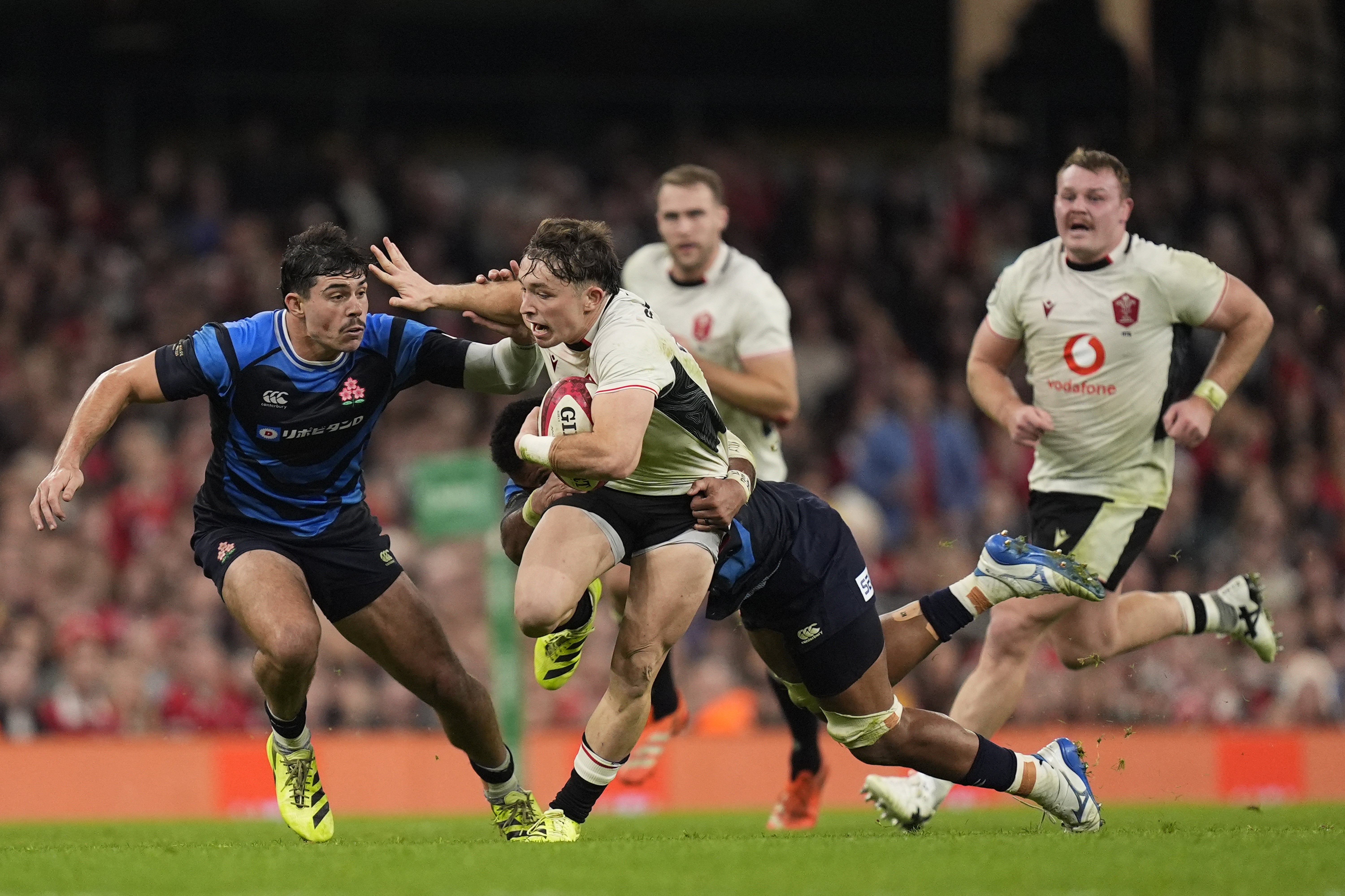 Dylan Riley de Japón (izquierda) y Dan Edwards de Gales (segundo desde la izquierda) luchan por el balón (Andrew Matthews/PA)