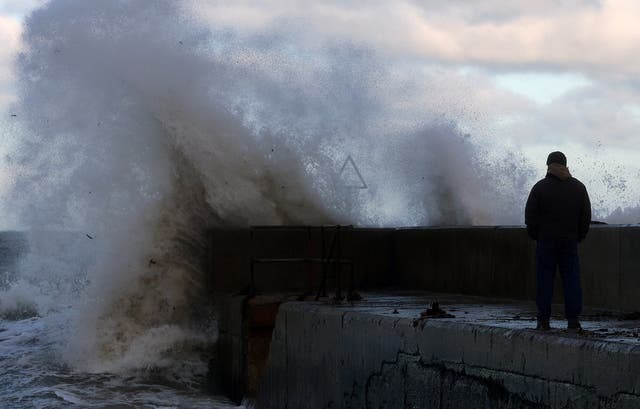 <p>Waves crash on a pier in the coastal village of Cushendall, Northern Ireland </p>