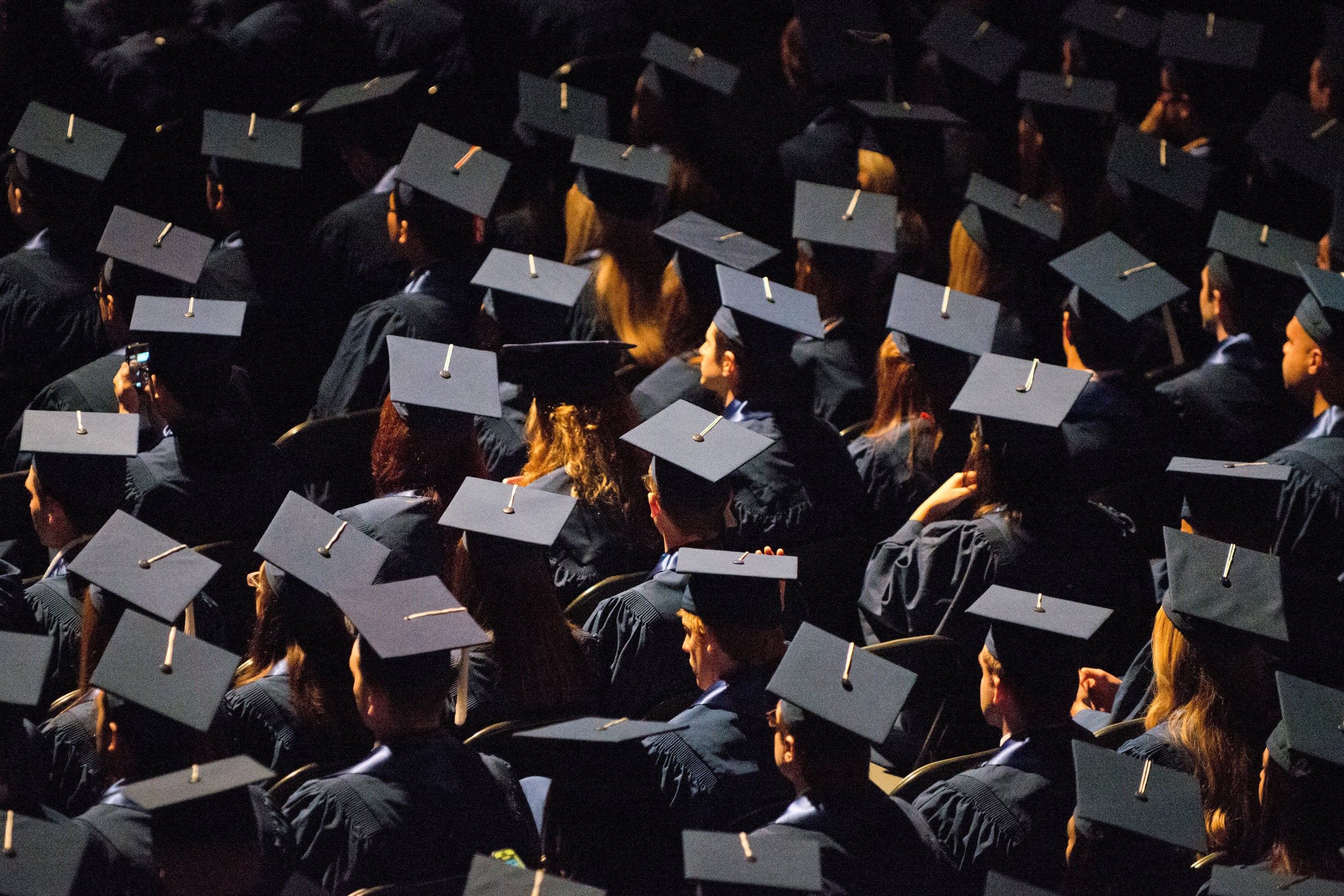 Students attend commencement ceremonies in the State Farm Center at the University of Illinois