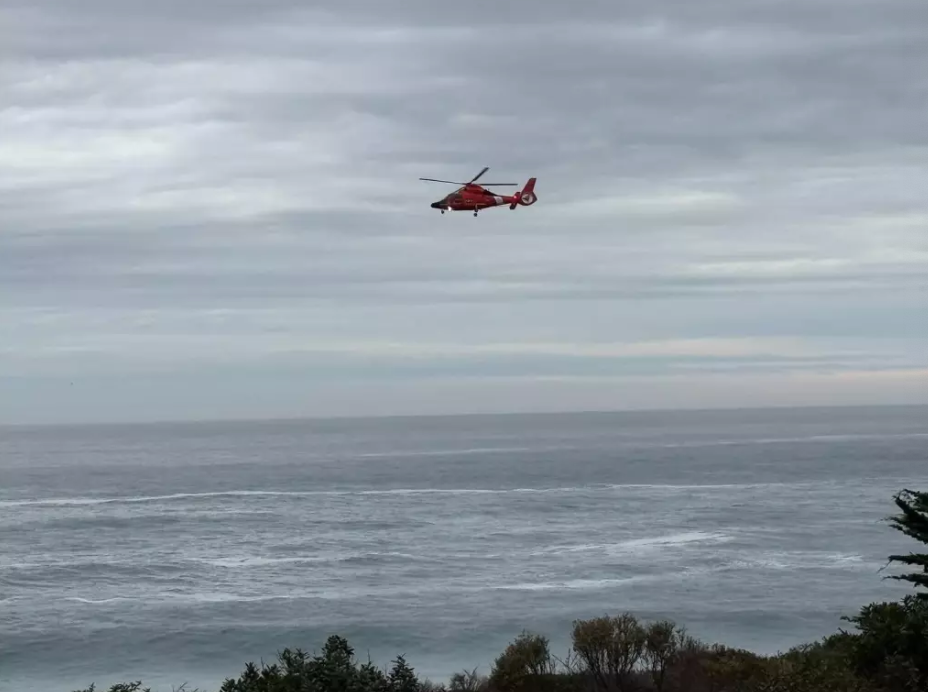 A U.S. Coast Guard helicopter searches the waters near Big Sur, California, for a 7-year-old girl who was swept into the ocean by a wave on Friday, November 14, 2025. Just over a week later, Coast Guard members were again searching the area for a 30-year-old man who was dragged into the ocean by a similar wave
