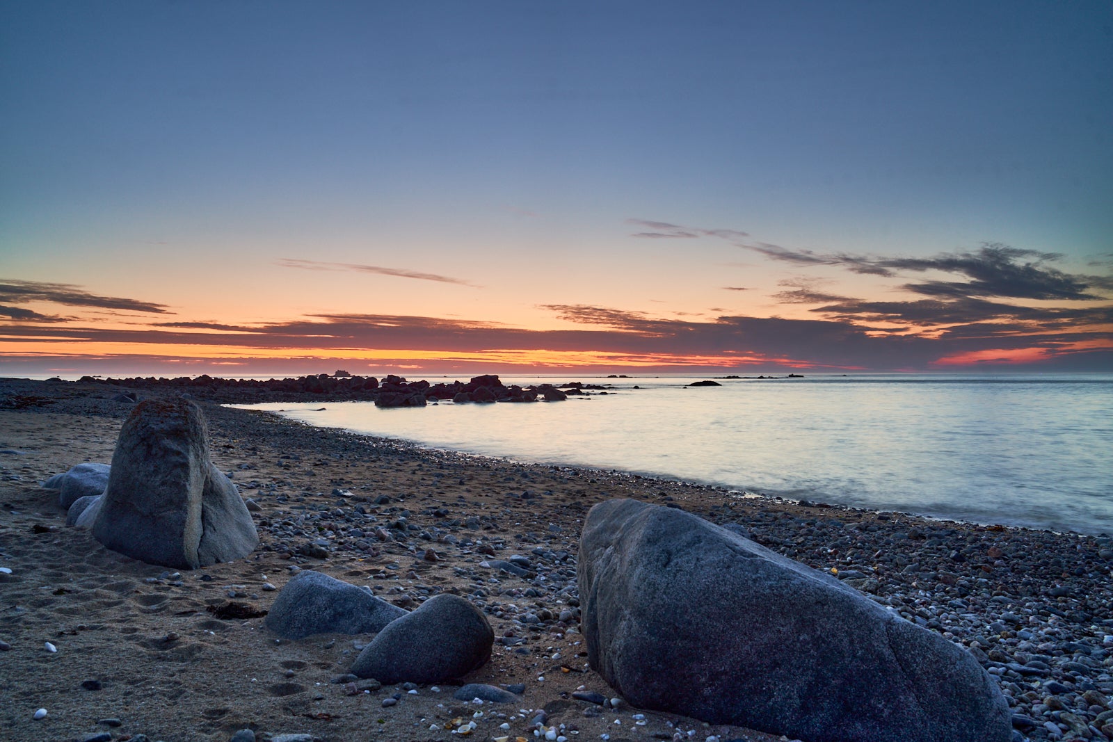 End of the day in Guernsey with the sun setting behind the shore