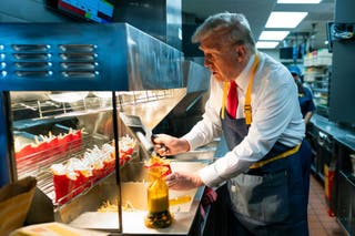 O então candidato presidencial Donald Trump trabalha atrás do balcão durante um evento de campanha em um restaurante McDonald's em 20 de outubro de 2024, em Feasterville-Trevose, Pensilvânia.