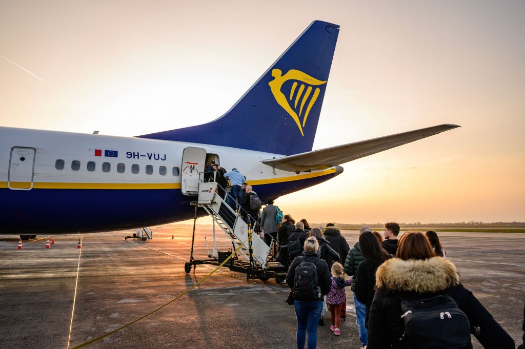 <p>Passengers wait to board a Ryanair plane</p>