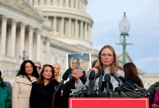 Annie Farmer, Maria Farmer’s sister, holds up a picture of the siblings at a press conference at the Capitol