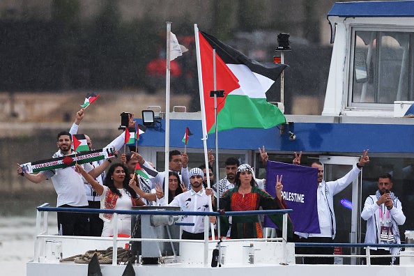 Tarazi sostiene la bandera palestina junto a sus compañeros atletas.