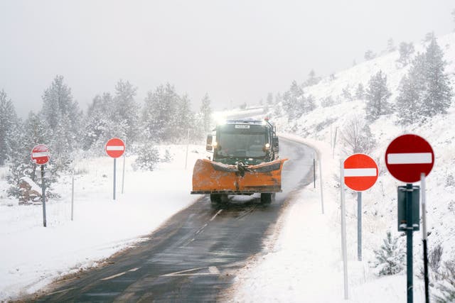 <p>A snow plough on the road near Aviemore, in the Scottish Highlands</p>