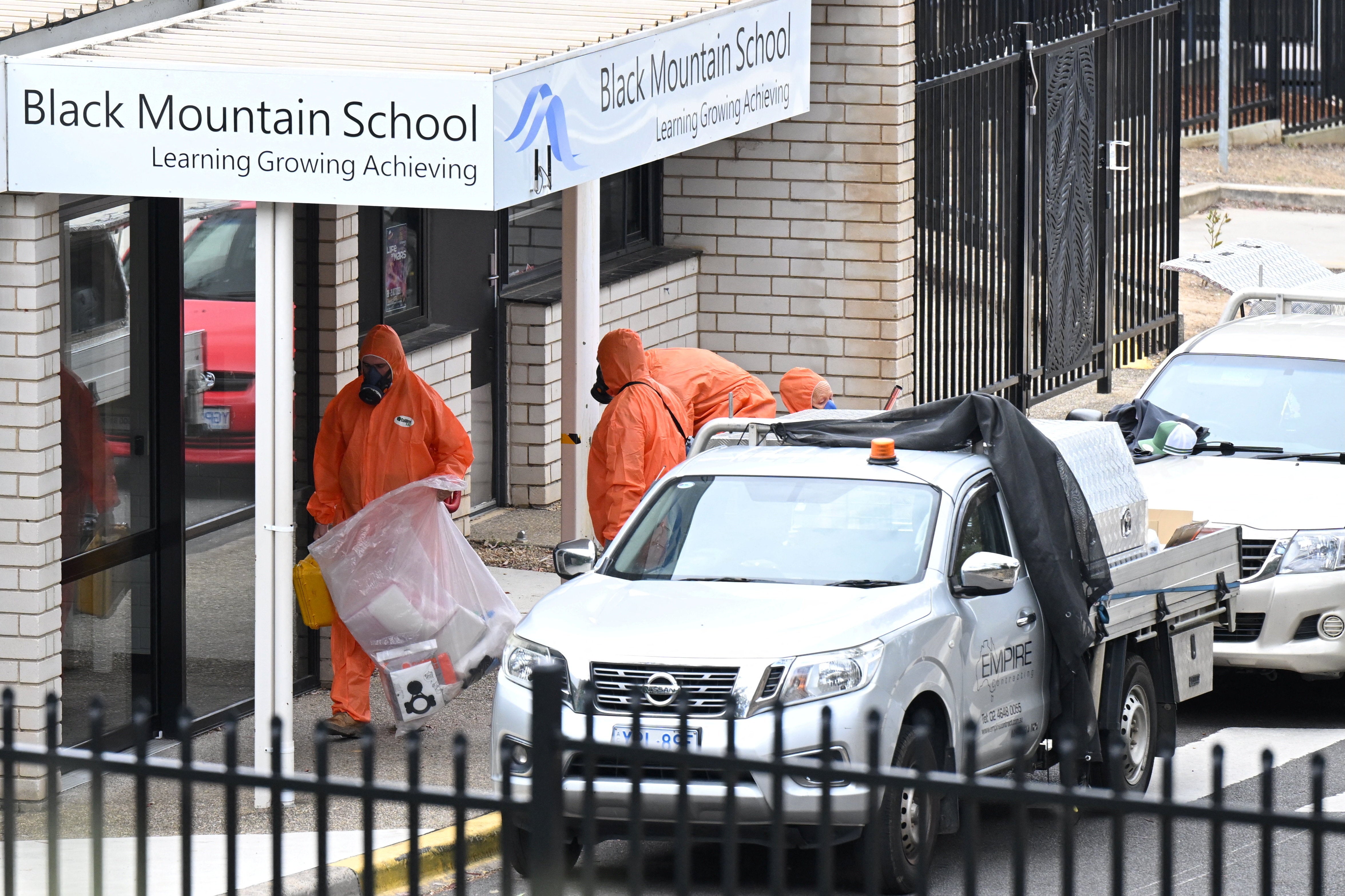 Removedores de amianto credenciados frequentam a Black Mountain School em Canberra em 17 de novembro de 2025