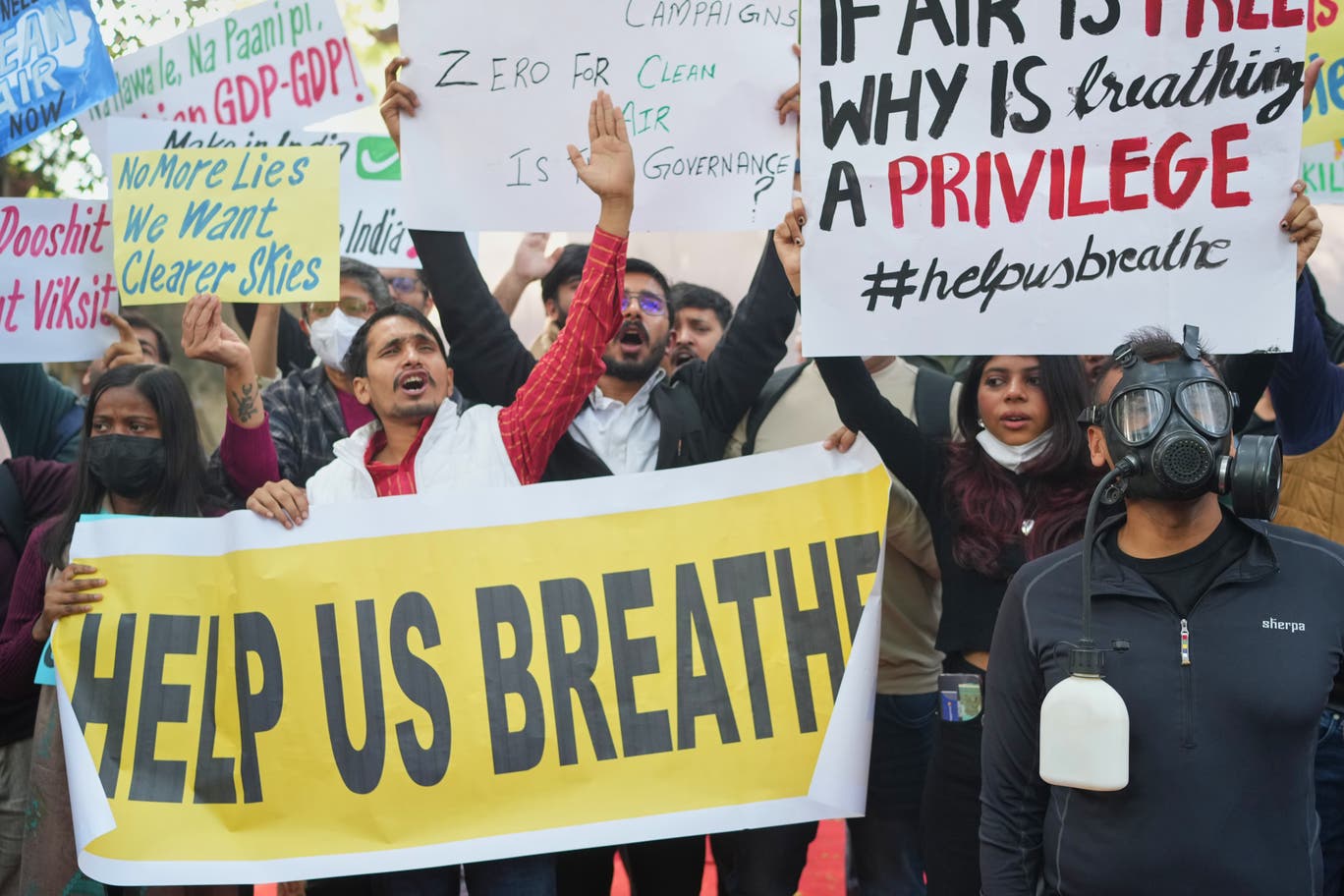 Protesters are seen holding signs in Delhi, India