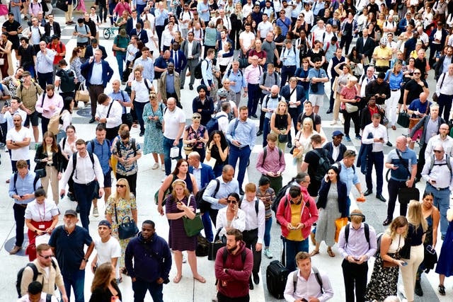 <p>A crowd of people looking at phones while walking</p>