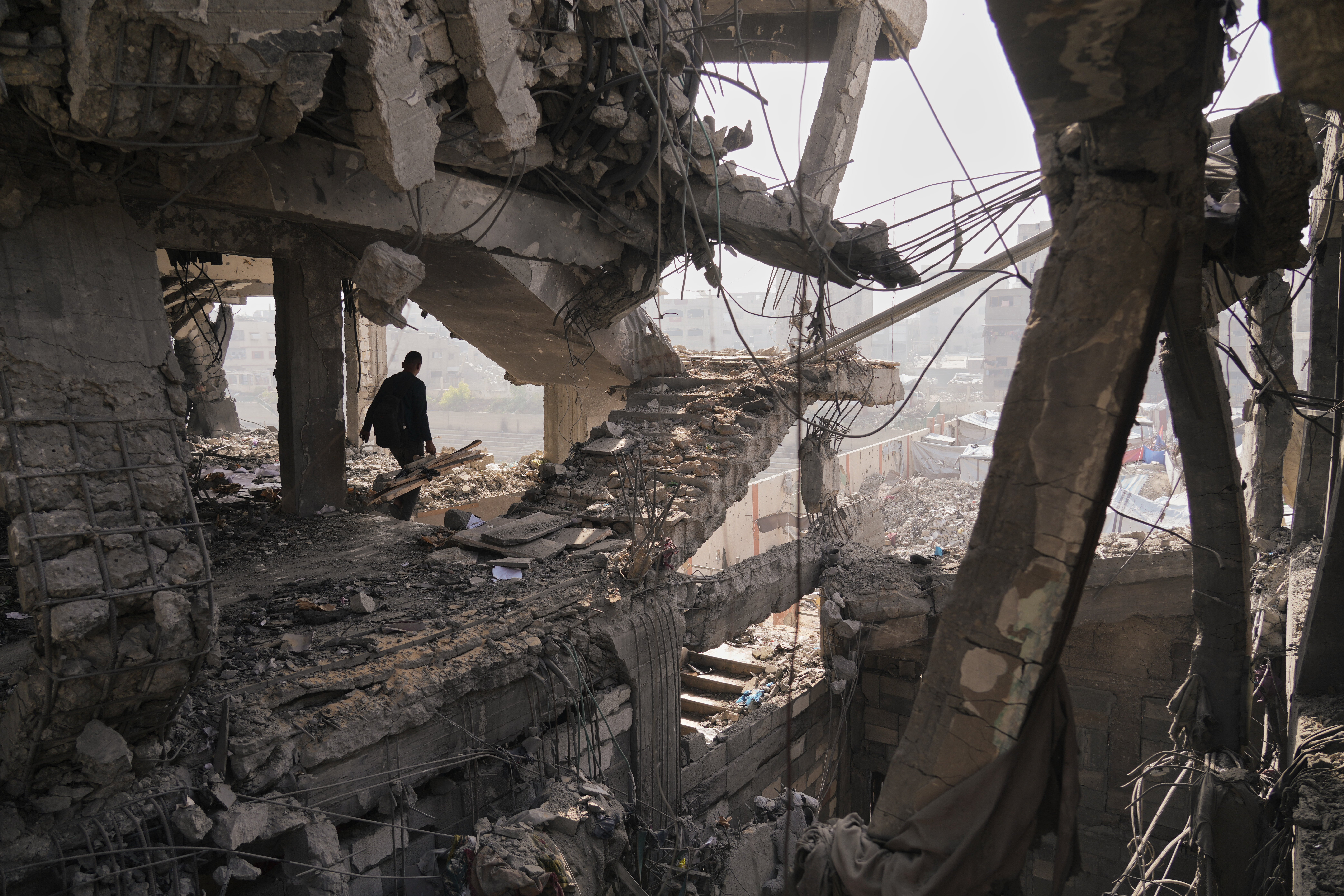 Palestinians inspect the ruins a day after an Israeli strike on a building in Gaza City