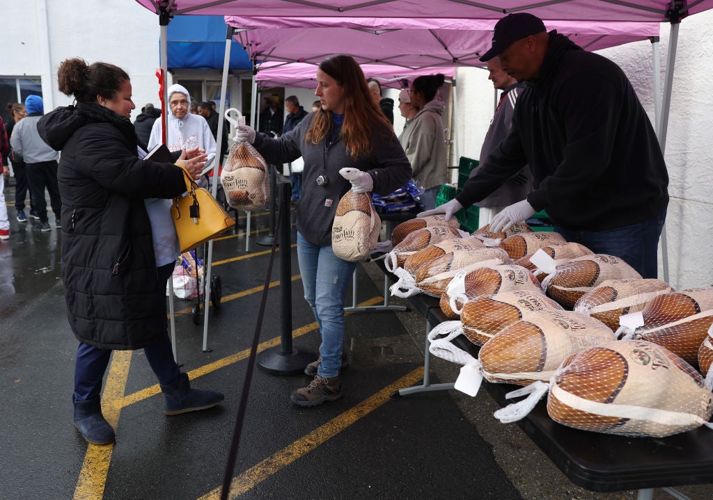 A volunteer hands a turkey to a person in need during the Bay Area Rescue Mission's annual turkey giveaway last year. Turkey prices are up this year