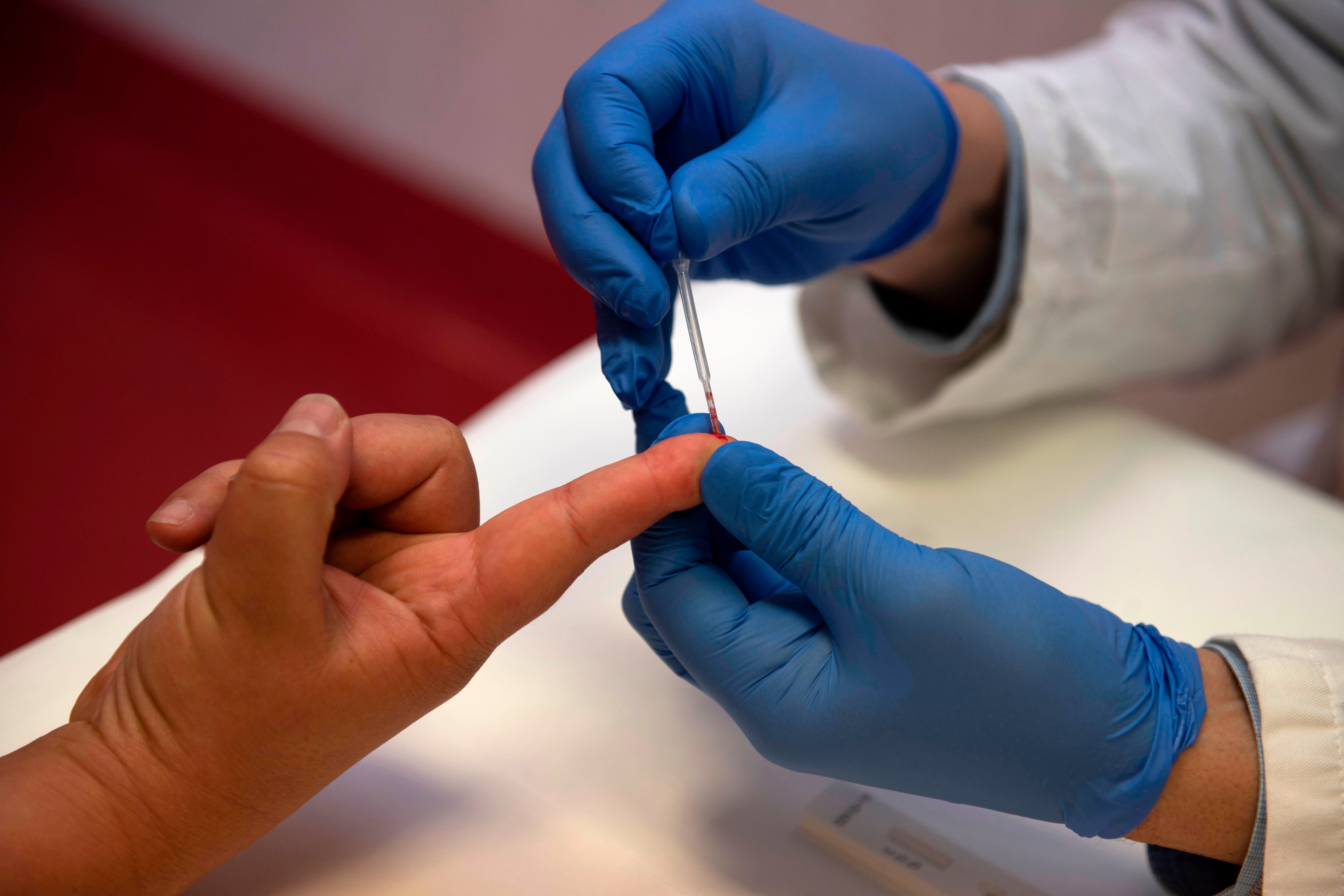 <p>Person undergoes a finger prick blood sample collection</p>