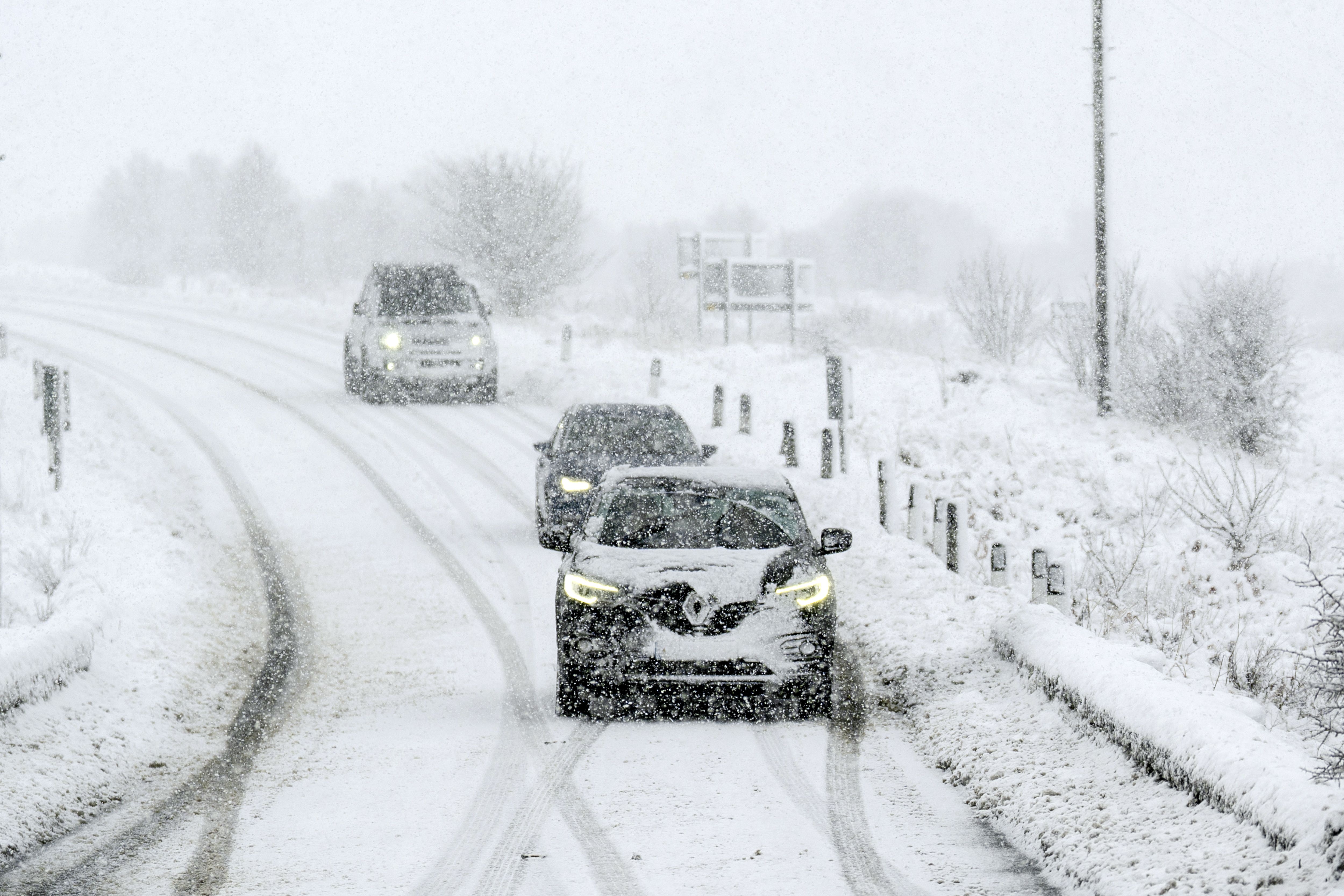 <p>Cars driving through snow on the A169 between Pickering and Whitby on the North Yorkshire Moors (Danny Lawson/PA)</p>