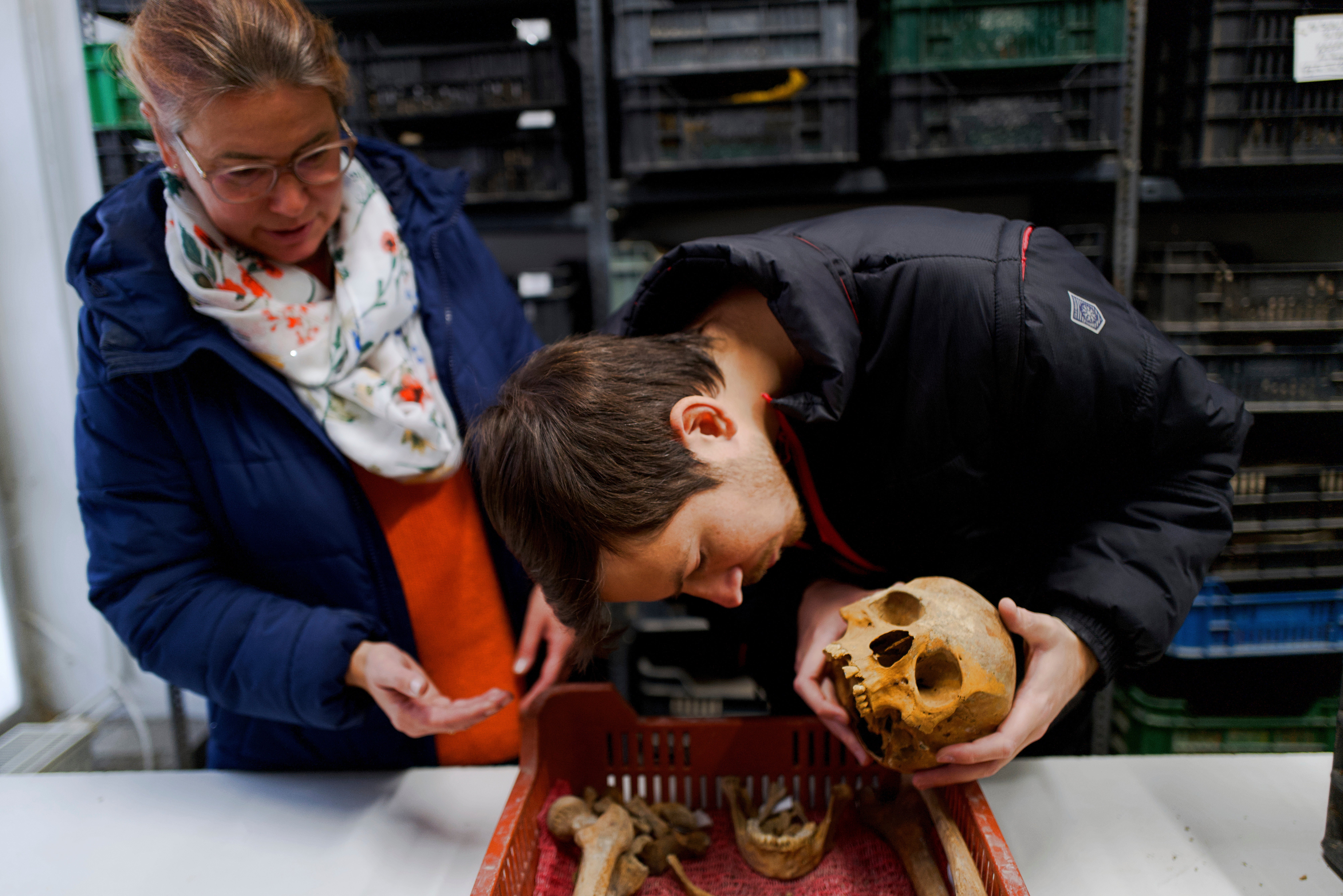 Hungarian archaeologists Gabriella Fenyes, left, and Gergely Kostyal inspect the skull of a Roman-era woman after her remains were found, Wednesday, Nov. 19, 2025 in Budapest, Hungary. (AP photo/Bela Szandelszky)