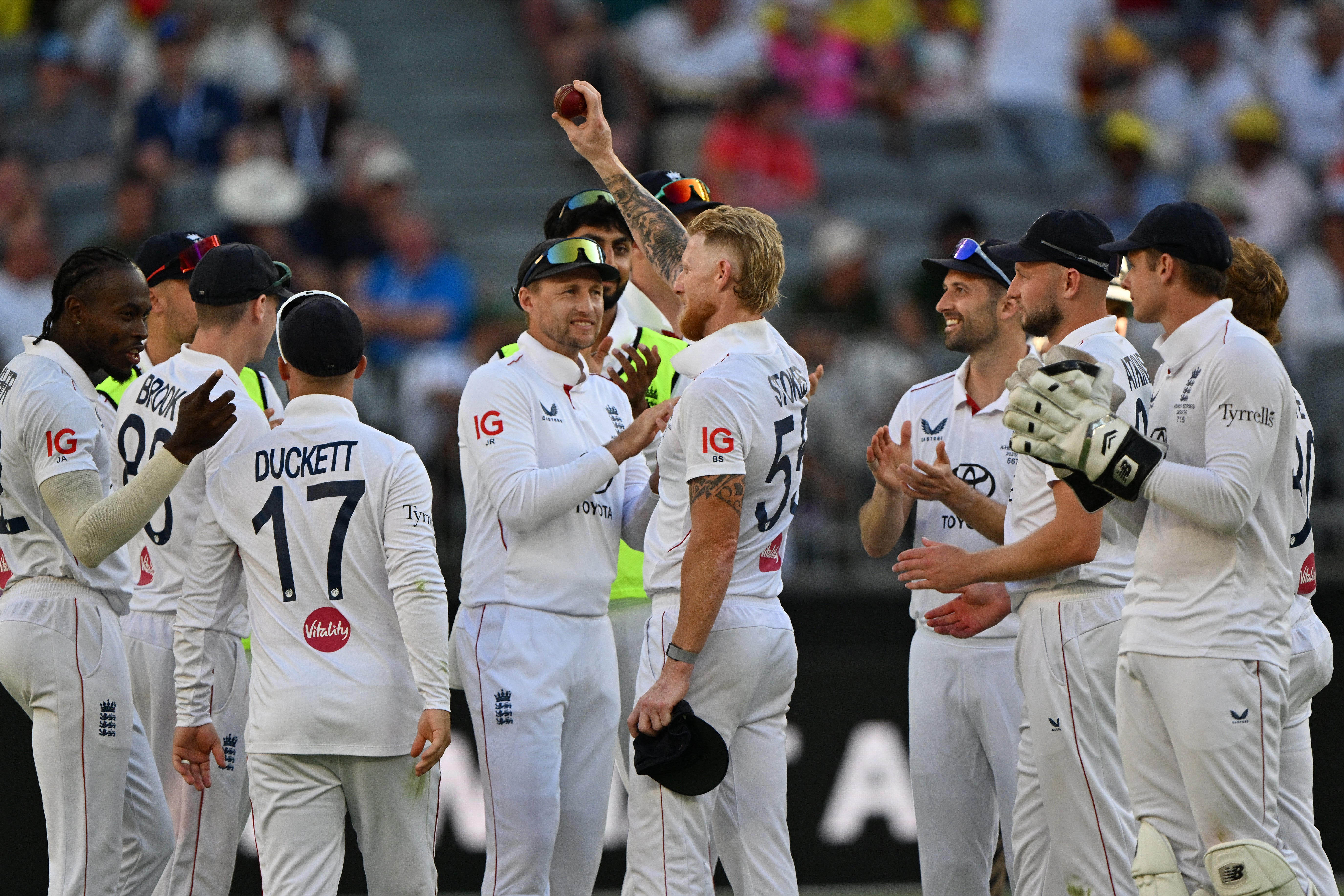 England's Ben Stokes (C) celebrates his five wickets with teammates on day 1