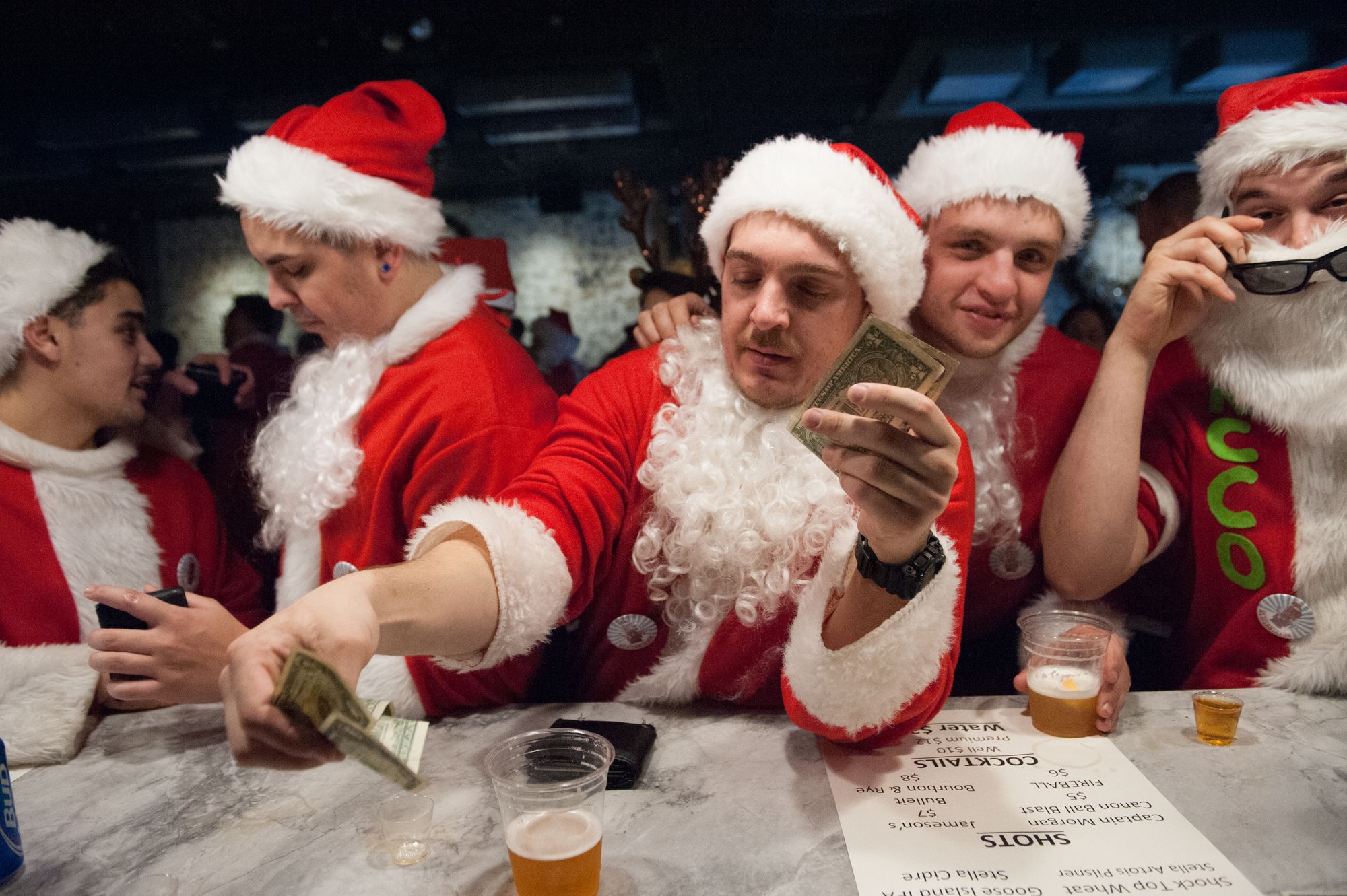 Men dressed as a Santa Claus drinking beer at a bar in Brooklyn, New York City, as part of SantaCon