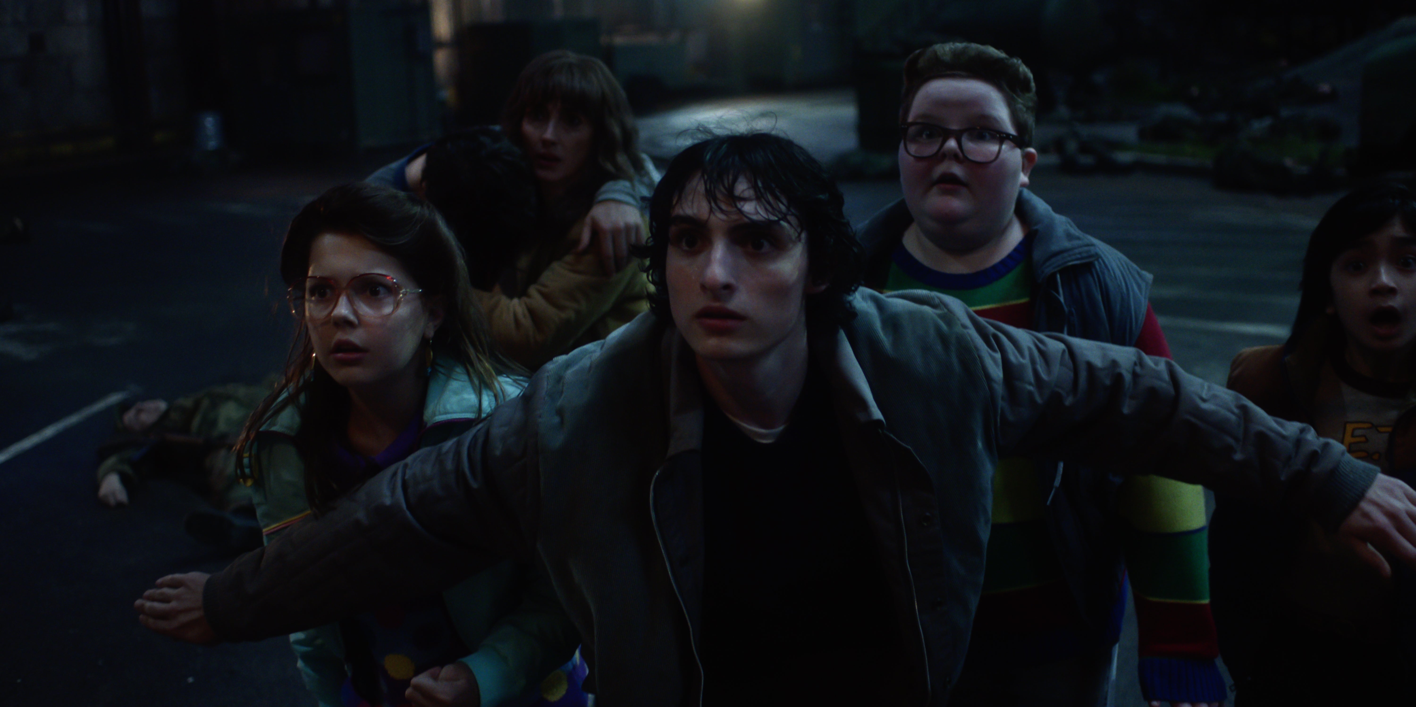 Finn Wolfhard (center) returns as Mike Wheeler, alongside Winona Ryder (back) as Joyce Byers
