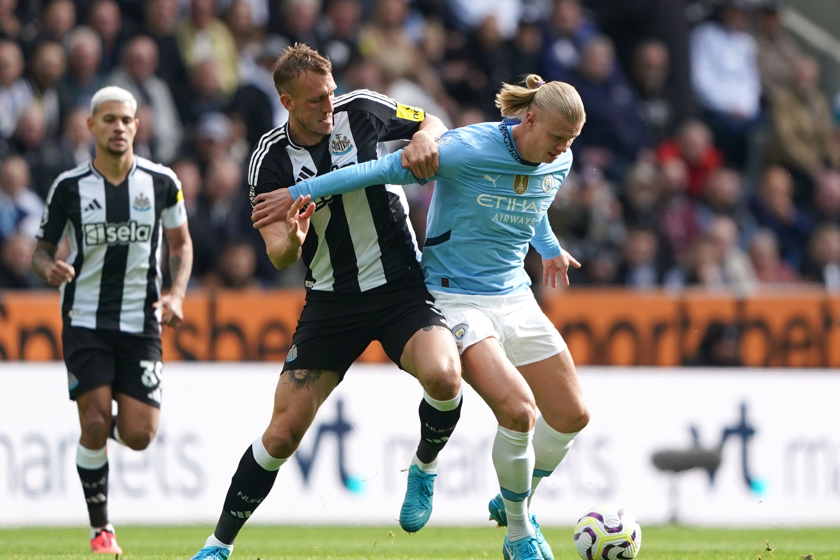 Newcastle’s Dan Burn (left) and Manchester City’s Erling Haaland battle for the ball (Owen Humphreys/PA)