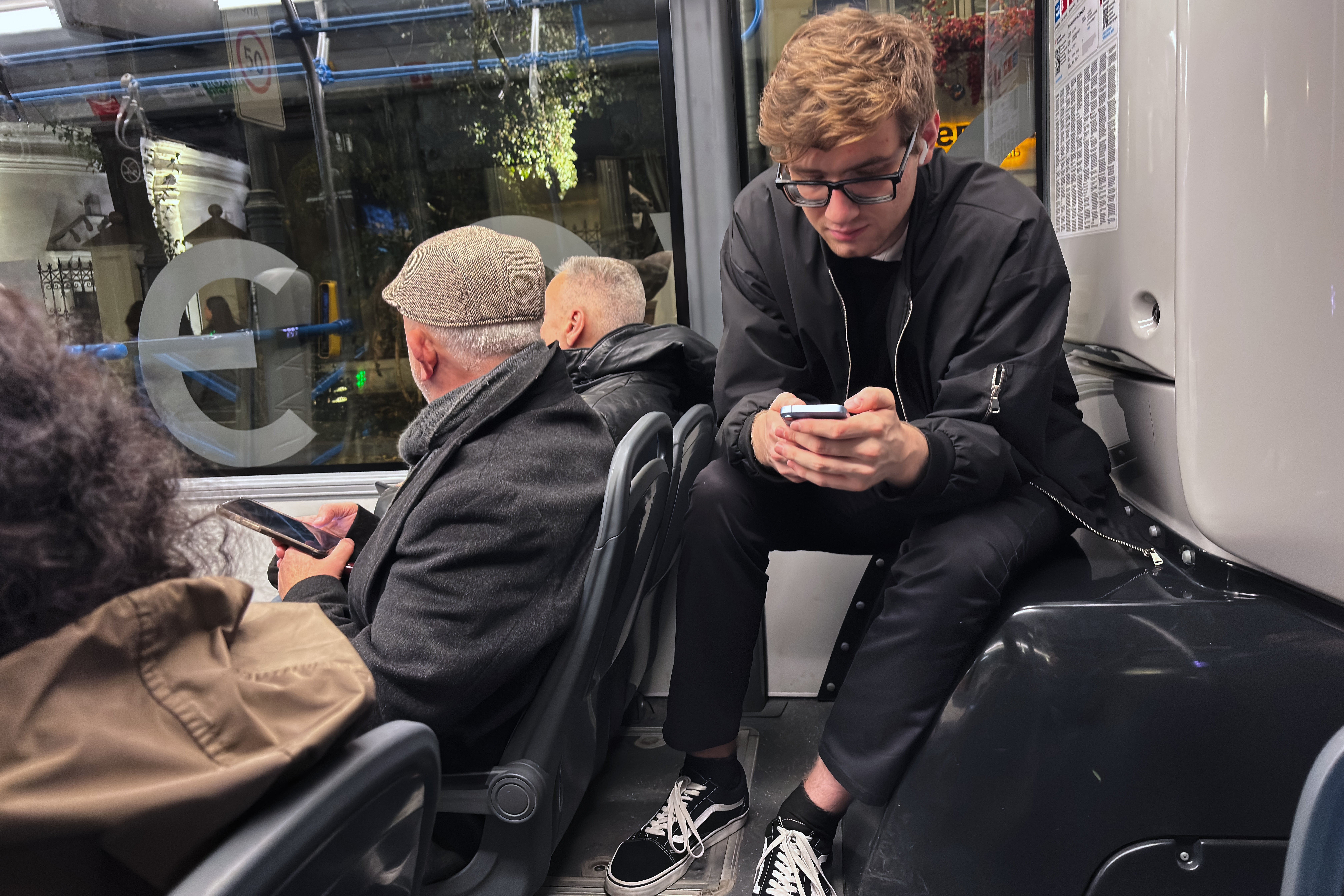 Passengers look at their smartphones on a bus in Moscow, Oct. 23, 2025. (AP Photo/Alexander Zemlianichenko, File)