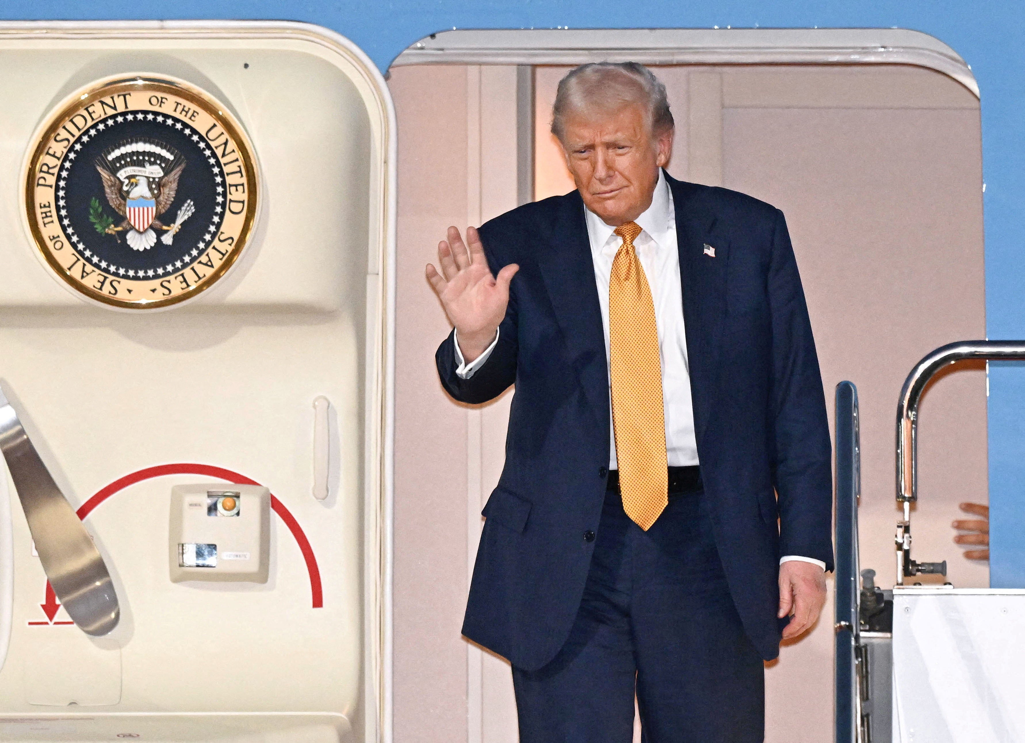 US president Donald Trump waves upon his arrival at Haneda airport in Tokyo, Japan, in this photo released by Kyodo 27 October 2025
