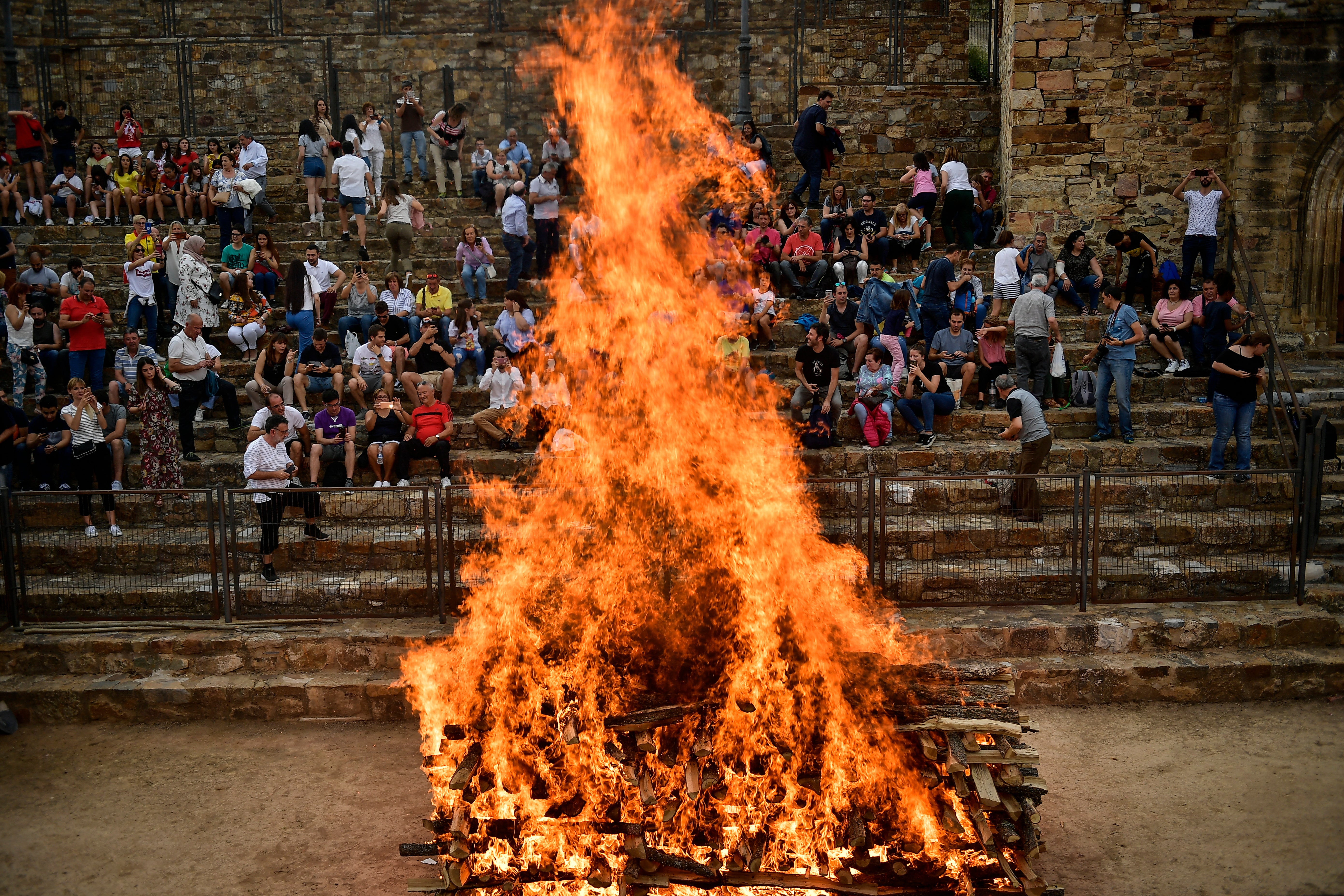 People view a fire before walking on the burning embers during the night of San Juan in San Pedro Manrique, northern Spain, June 23, 2019. (AP Photo/Alvaro Barrientos, File)