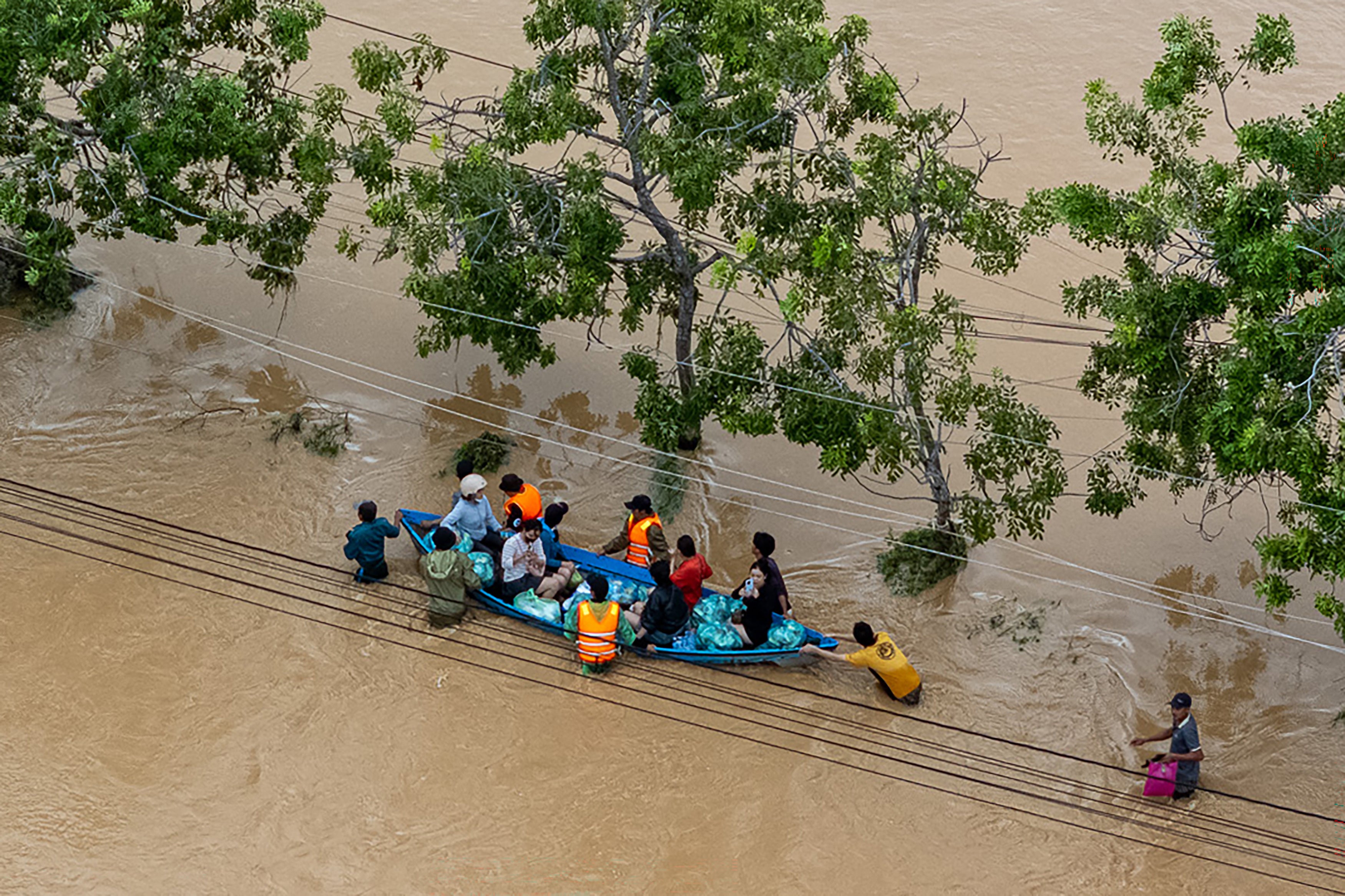 <p>This aerial photo shows people wading through floodwaters in Phan Rang in southern Vietnam's Khanh Hoa province on 21 November 2025</p>