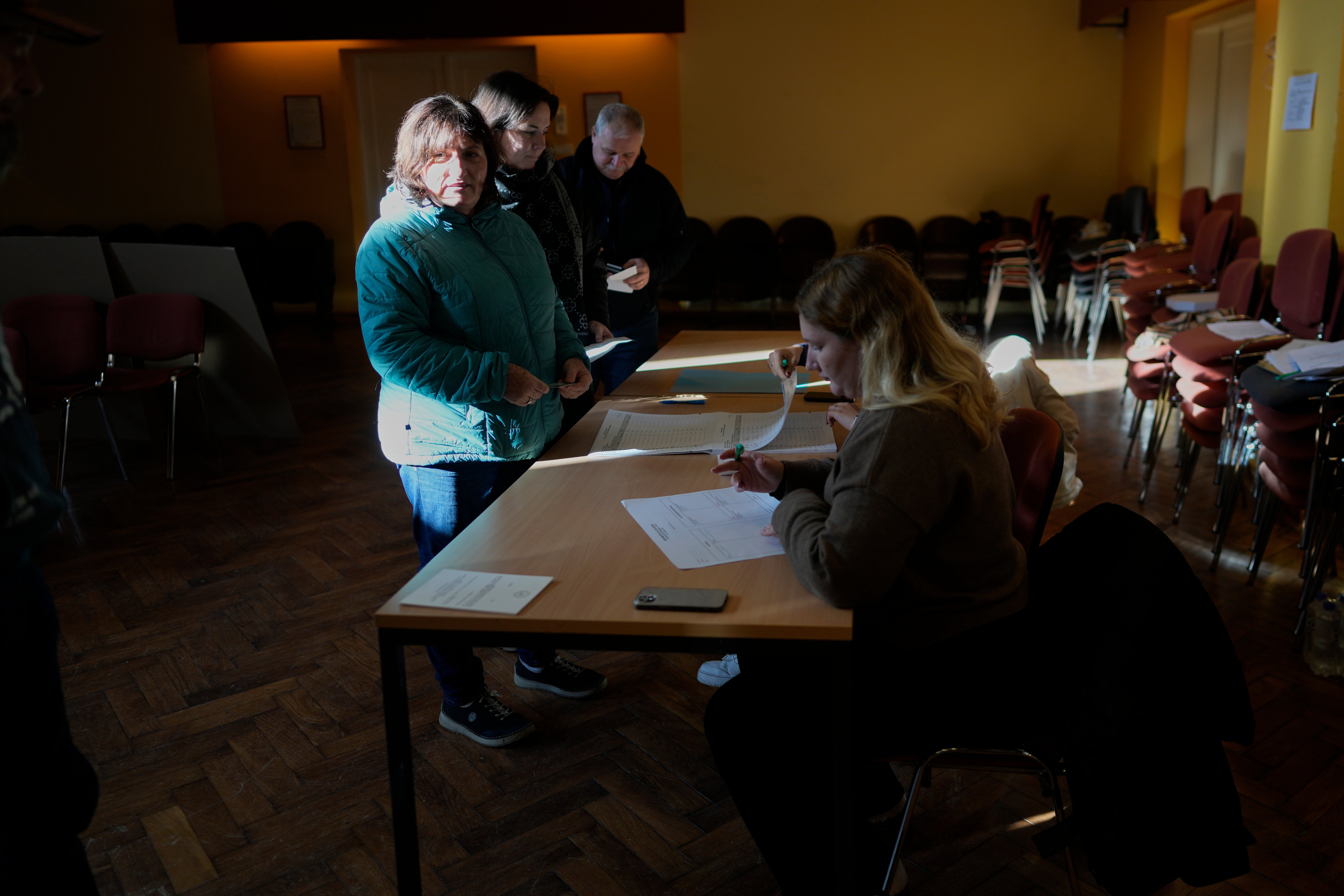 Voters register at a polling station during the referendum on assisted dying for terminally ill patients, in Domzale, Slovenia, Sunday, Nov. 23, 2025. (AP Photo/Darko Bandic)