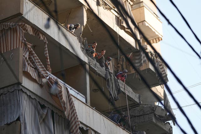 <p>Civil Defence workers inspect damage at an residential building after an Israeli attack in southern Beirut</p>