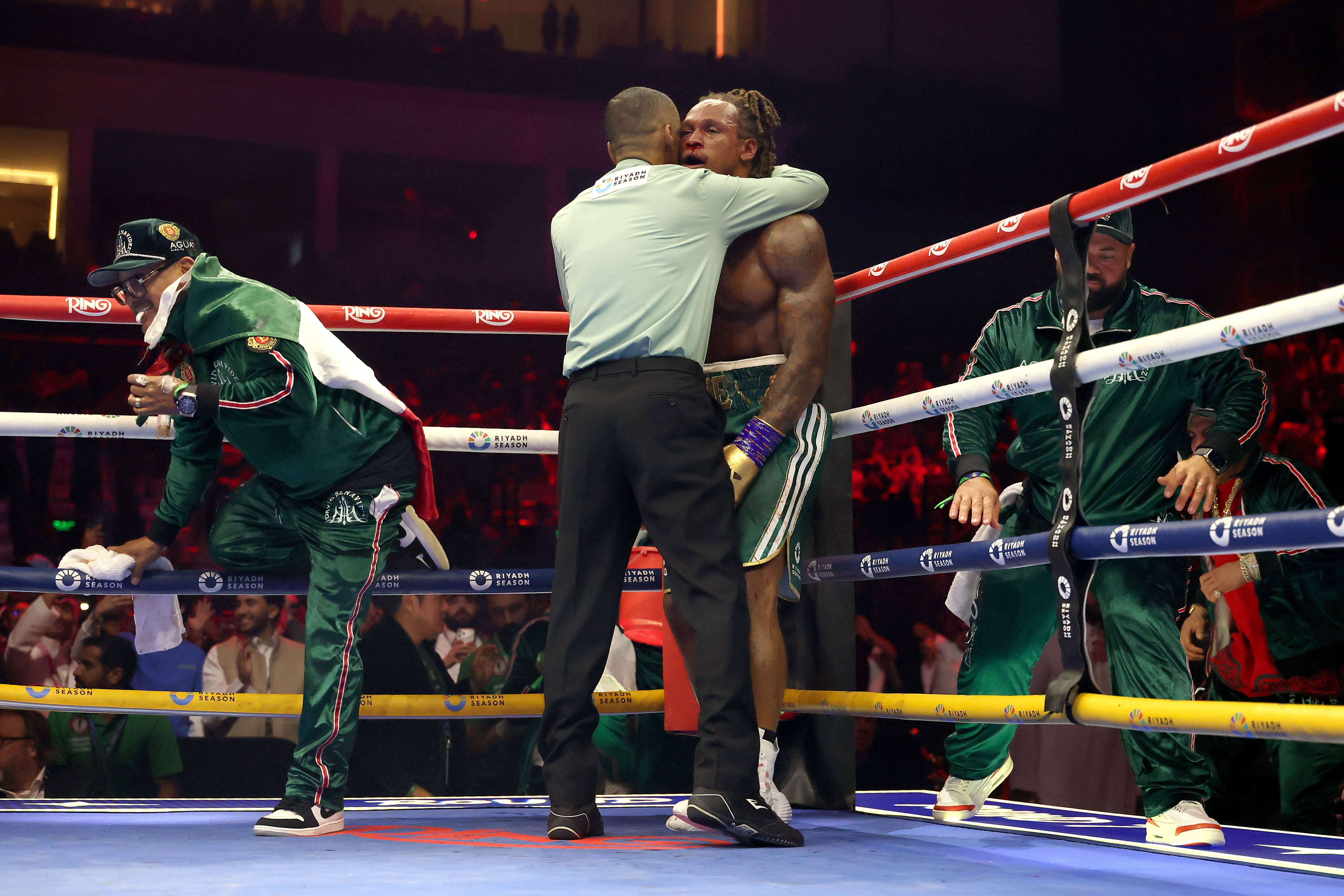 Referee Hector Afu (L) stops the fight in round seve