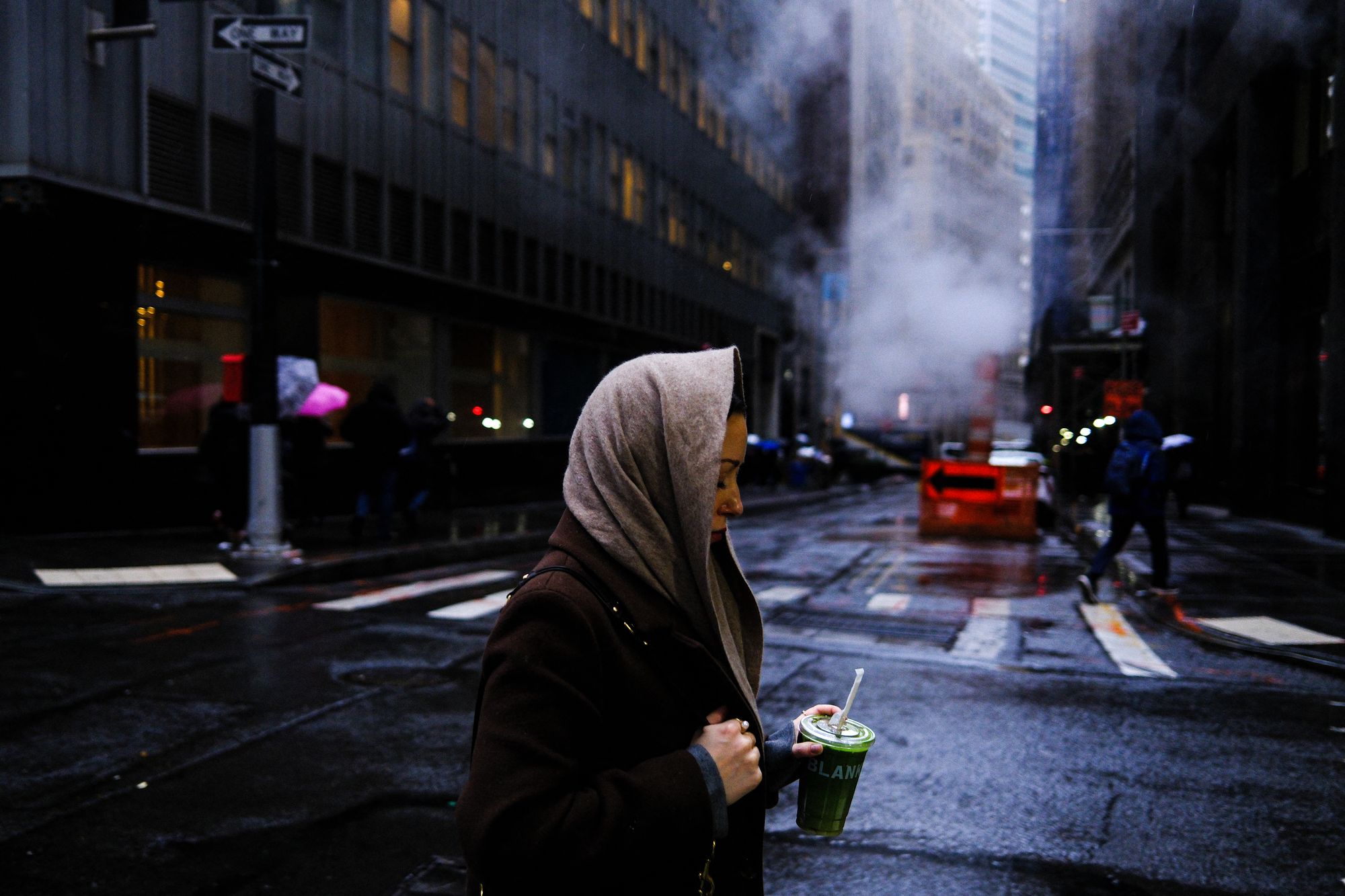A woman walks on the street as the rain pours in the Manhattan borough of New York City on November 19, 2025