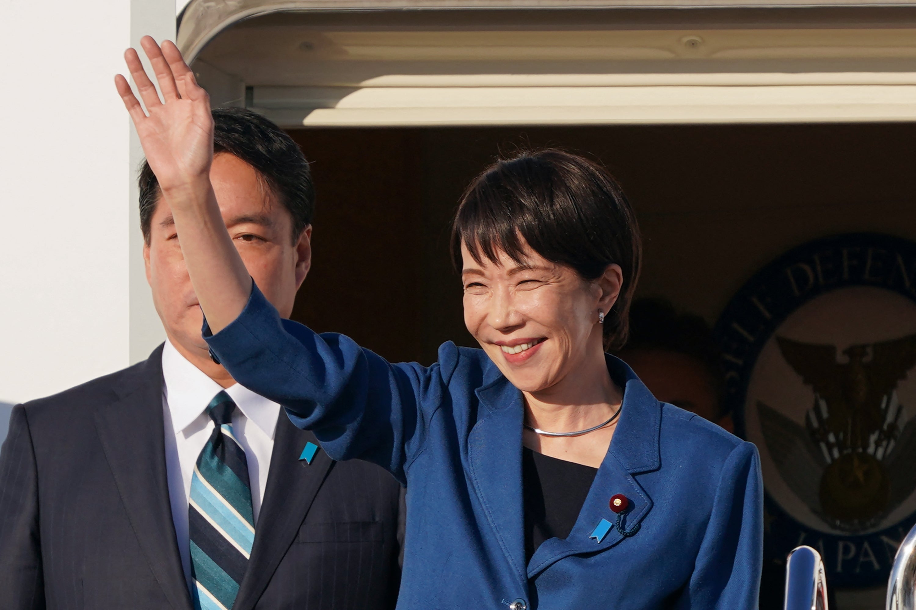 Japan's Sanae Takaichi waves waves as she departs for the G20 summit in South Africa