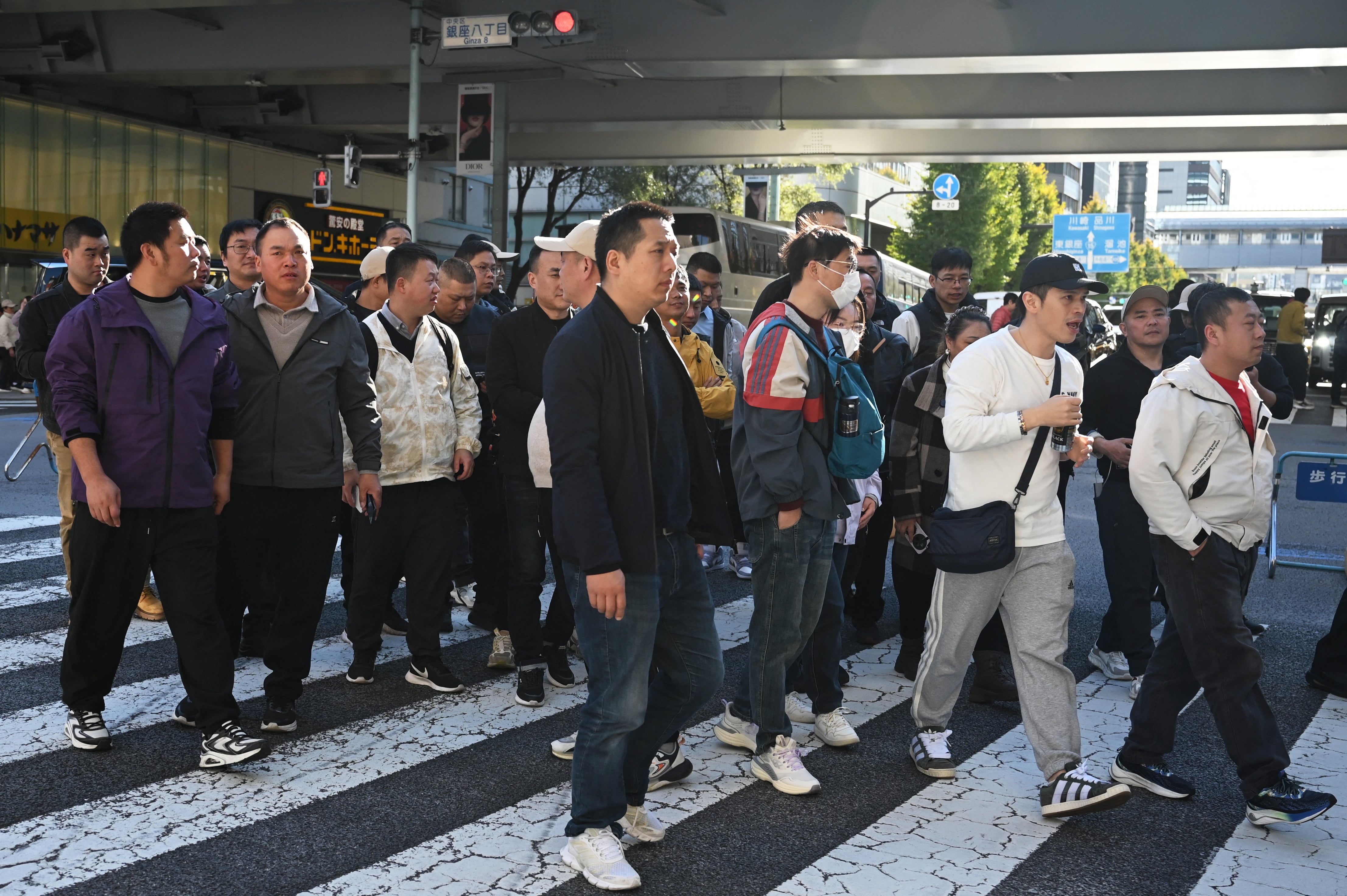 Tourists from China cross a road in the Ginza shopping district of Tokyo on 22 November 2025