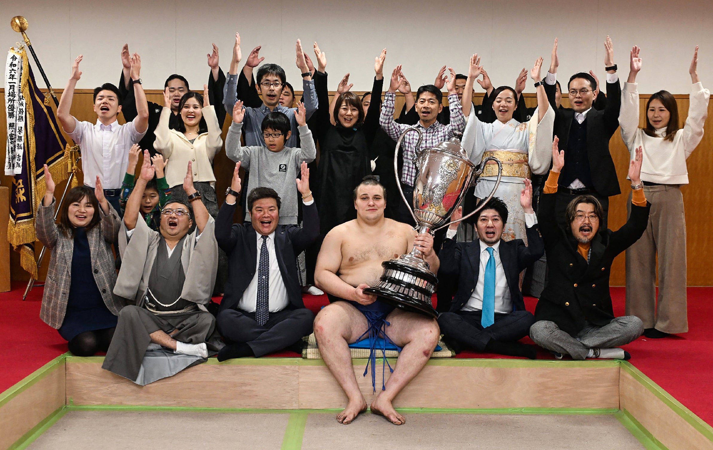 Ukrainian sumo wrestler Danylo Yavhusishyn (front C), also known by his Japanese ring name Aonishiki Arata poses with the trophy to celebrate after winning the Grand Sumo Tournament in Fukuoka on November 23, 2025. (Photo by JIJI PRESS / AFP via Getty Images) / Japan OUT