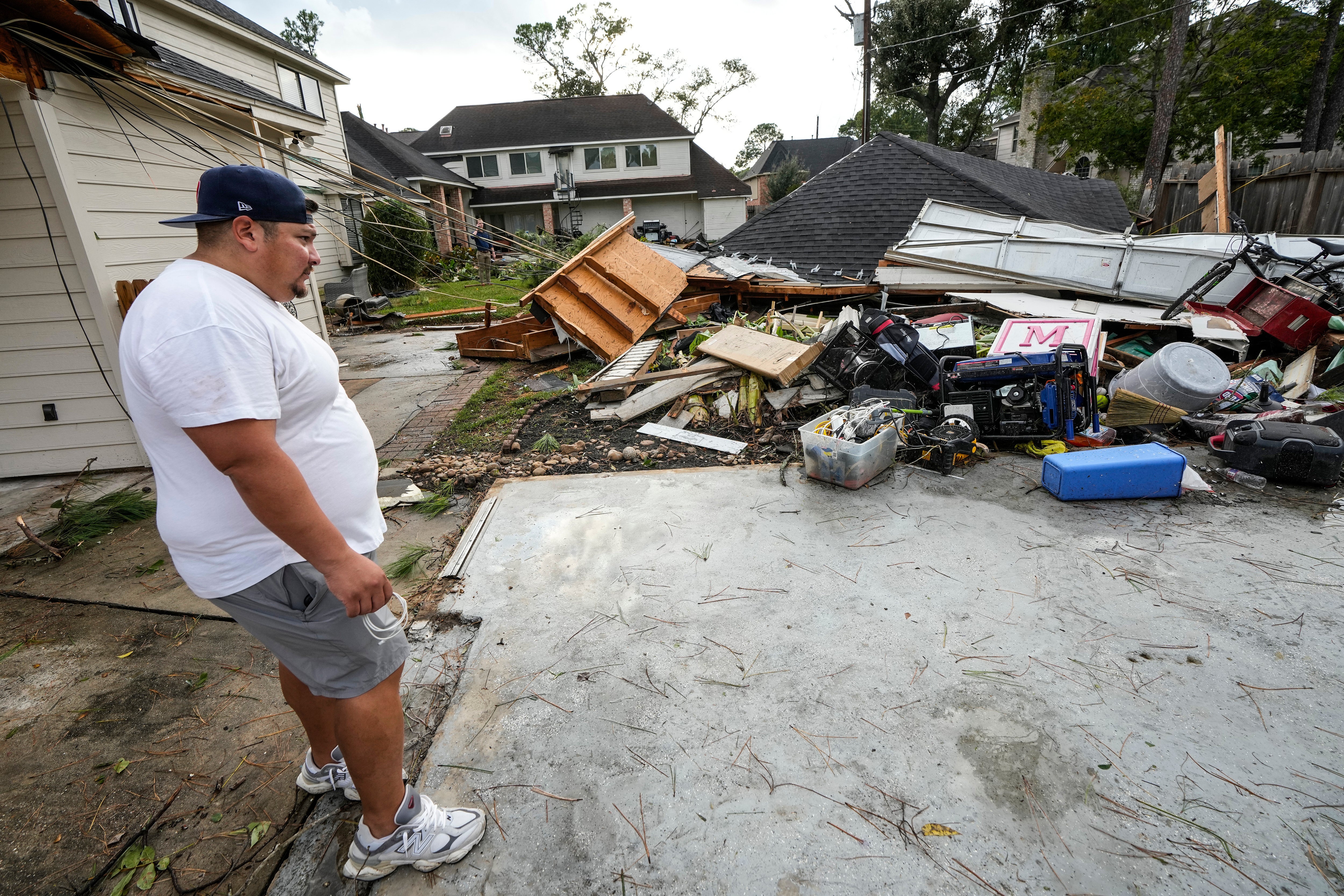 Guillermo Vargas surveys damage to his home, where his garage was swept off its foundation, while cleaning up storm damage after severe weather hit in the Memorial Northwest subdivision, in Spring, Texas, Monday, Nov. 24, 2025. (Brett Coomer/Houston Chronicle via AP)
