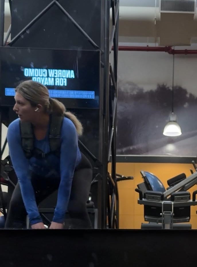 Musto lifts a kettlebell at a gym in New York City while wearing the weighted vest
