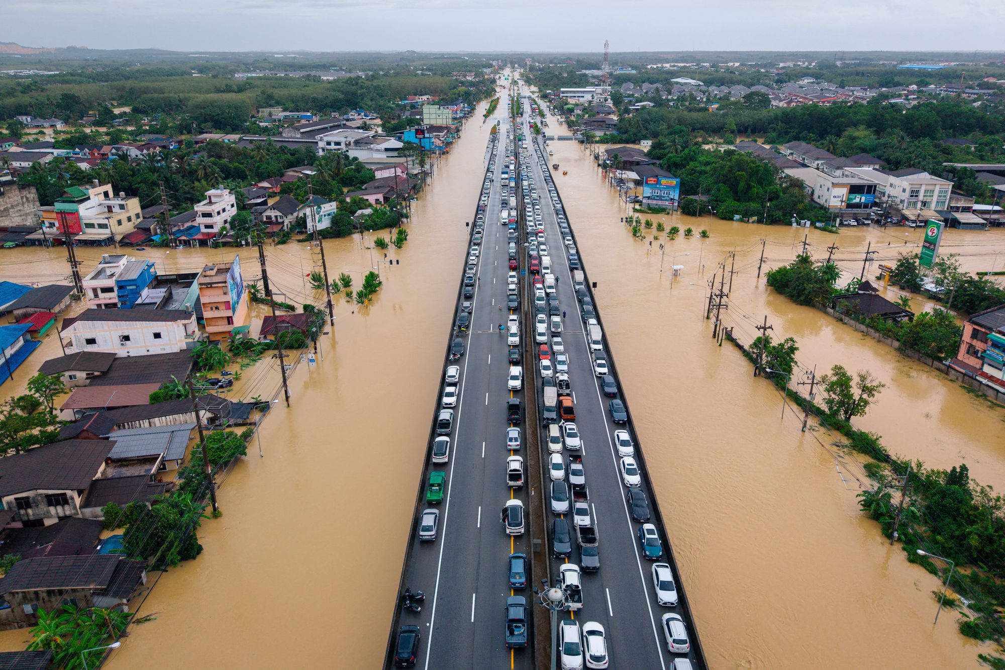 This aerial photo taken on November 25, 2025 shows vehicles parked on an elevated road to keep them out of flood waters in Hat Yai in Thailand's southern Songkhla province