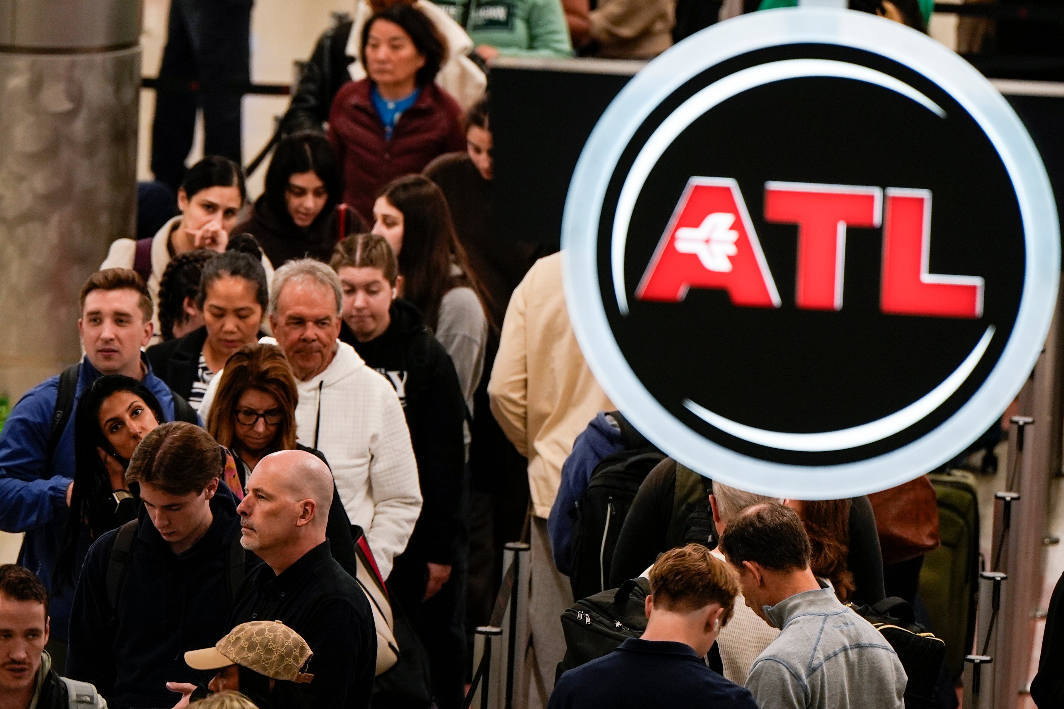 Travelers stand in line for departure at Hartsfield-Jackson Atlanta International Airport on Wednesday morning in Atlanta. Conditions there are dry for now, but expected to get colder over the next few days