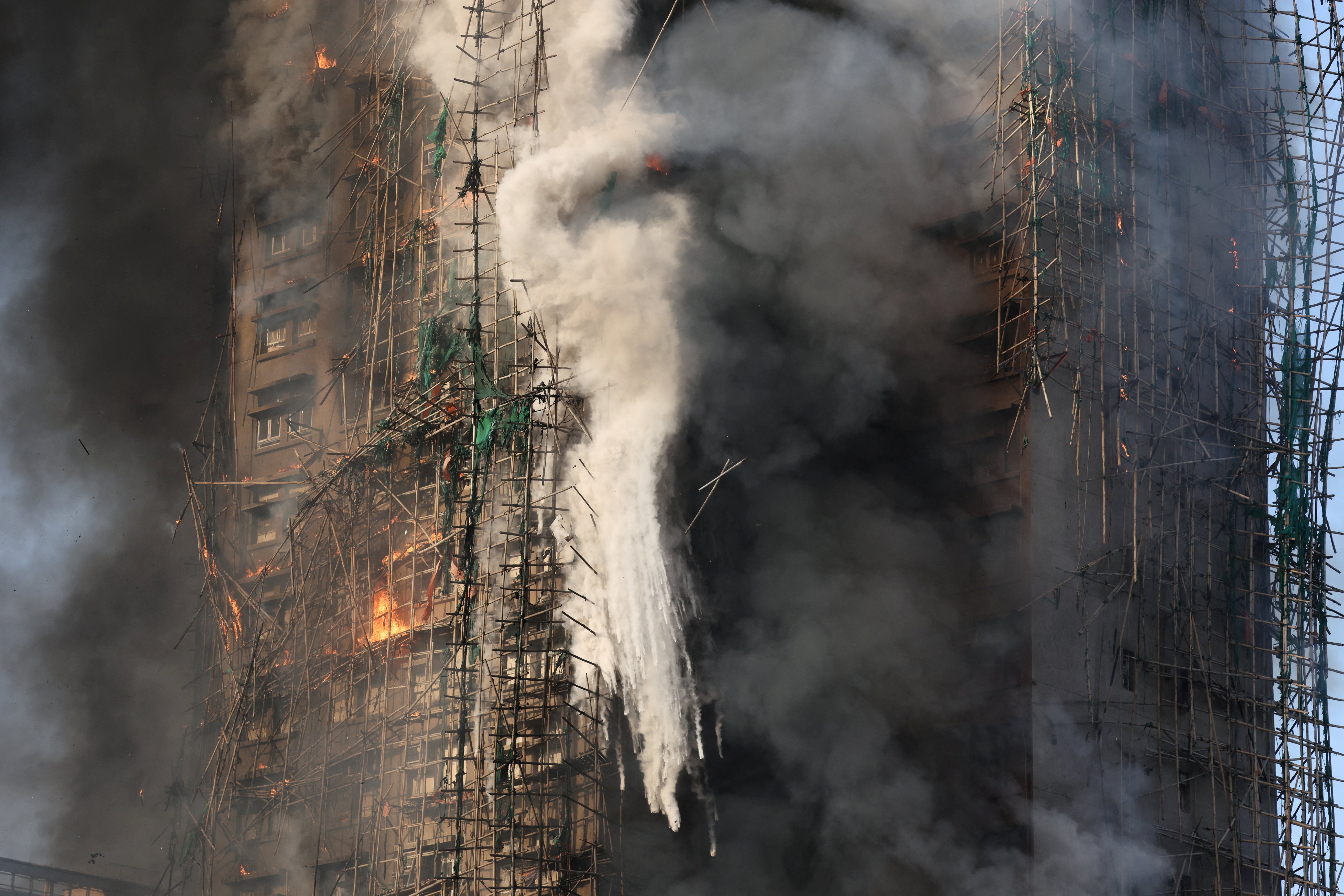 As chamas devoram os andaimes de bambu de vários edifícios no conjunto habitacional Wang Fuk Court, em Tai Po.