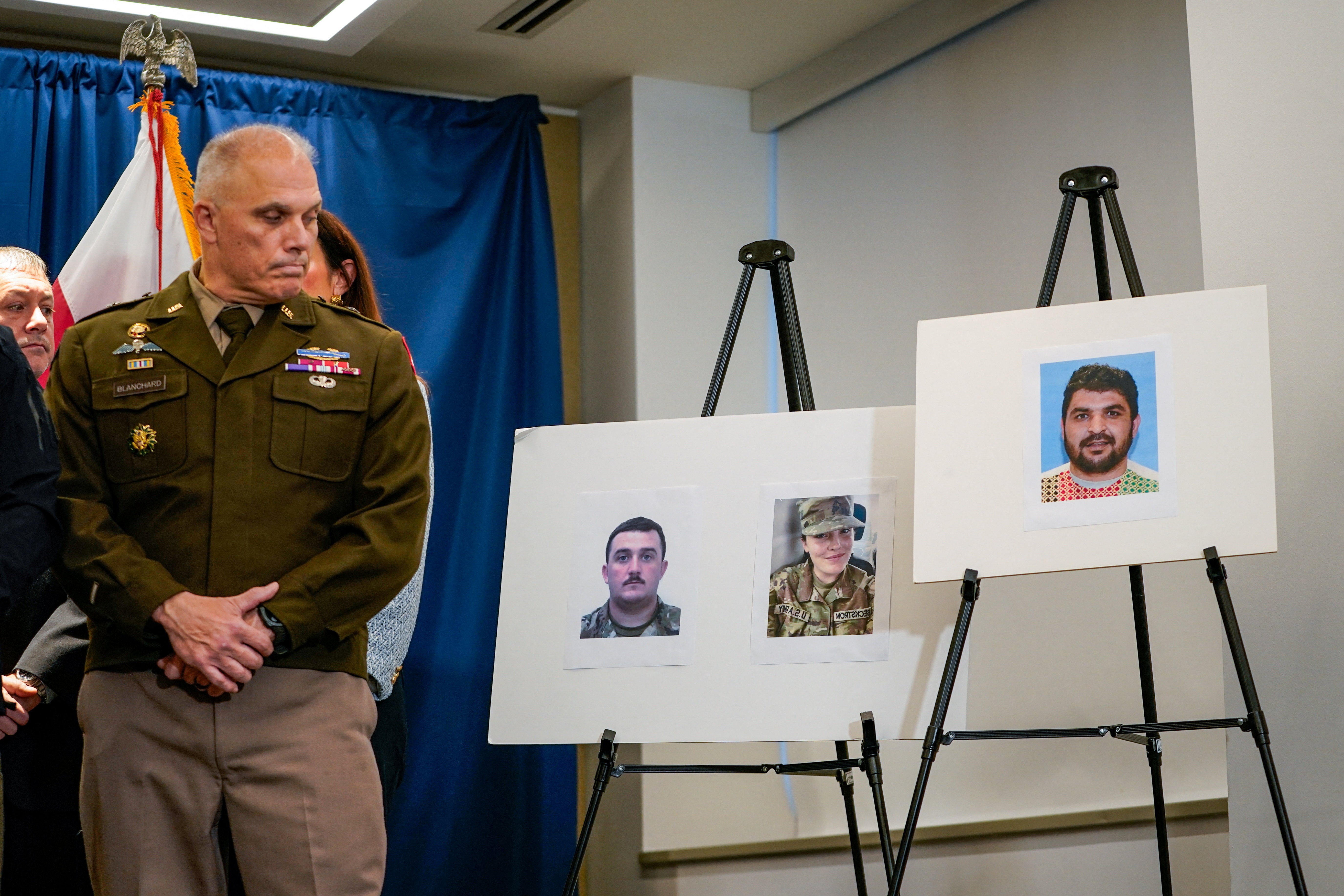 Brigadier General Leland D. Blanchard II looks towards pictures of two National Guard members who were shot in Washington