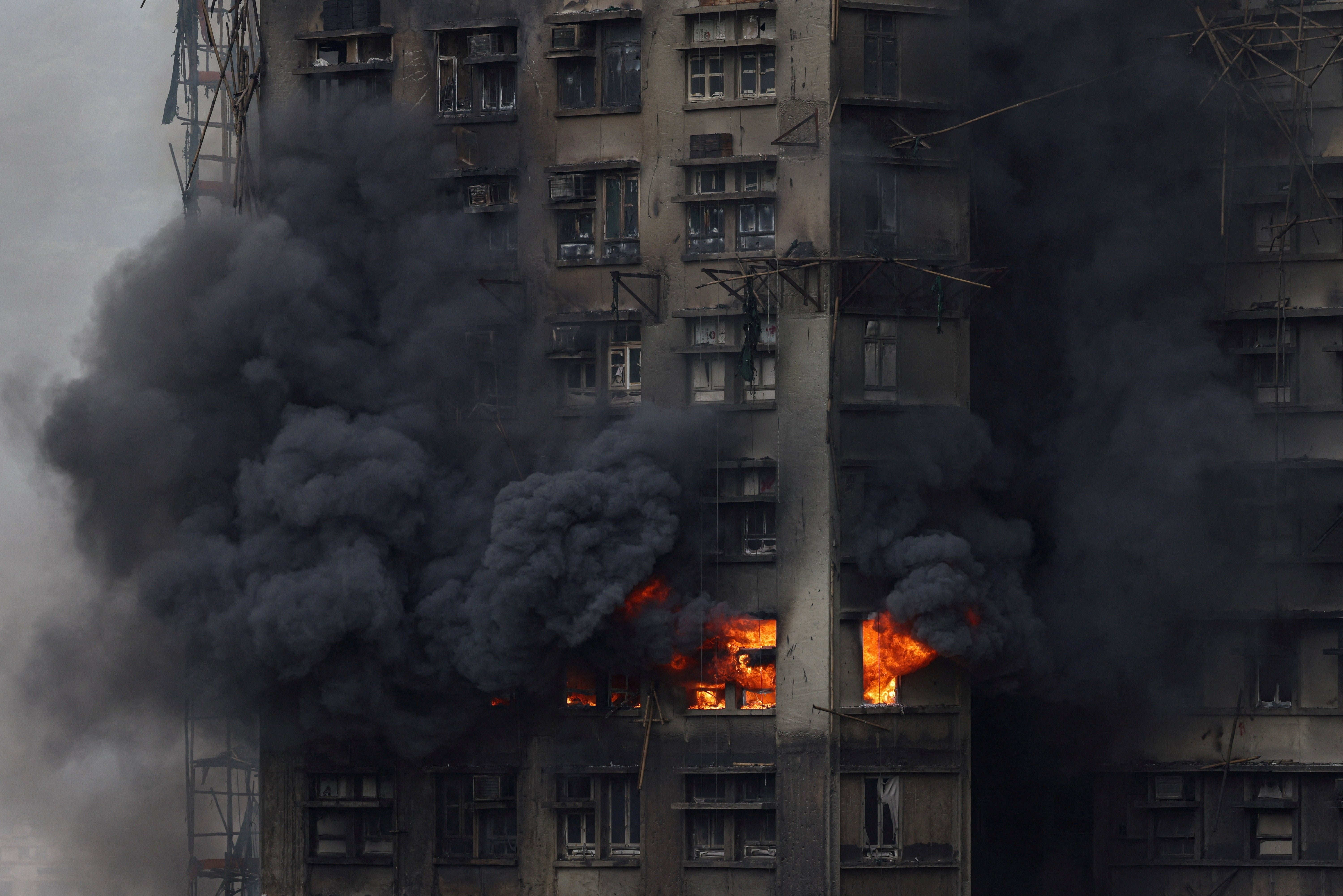Thick smoke billows from the upper floors of a residential block at Wang Fuk Court housing estate during a major fire that engulfed bamboo scaffolding across multiple buildings, in Tai Po, Hong Kong