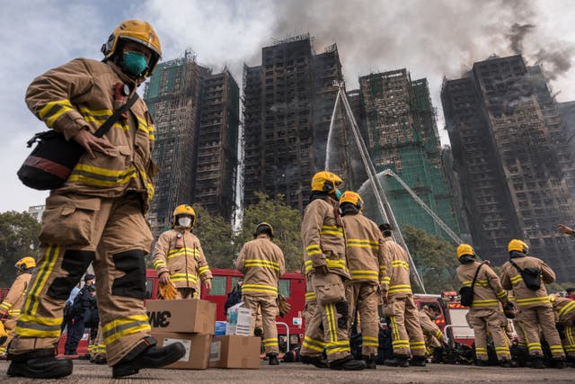 <p>Firemen get ready after a major fire swept through several apartment blocks at the Wang Fuk Court residential estate in Hong Kong's Tai Po district </p>