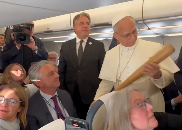 <p>Pope Leo is handed a baseball bat by a reporter.</p>