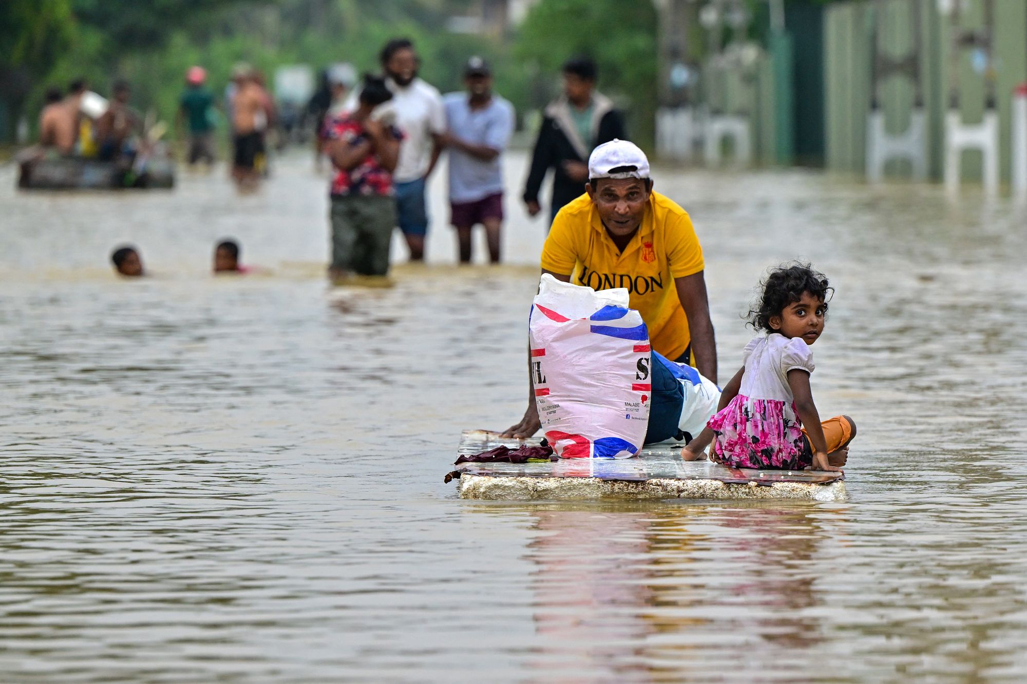 A man pushes a makeshift raft along a flooded street after heavy rainfall in Ambatale on the outskirts of Colombo