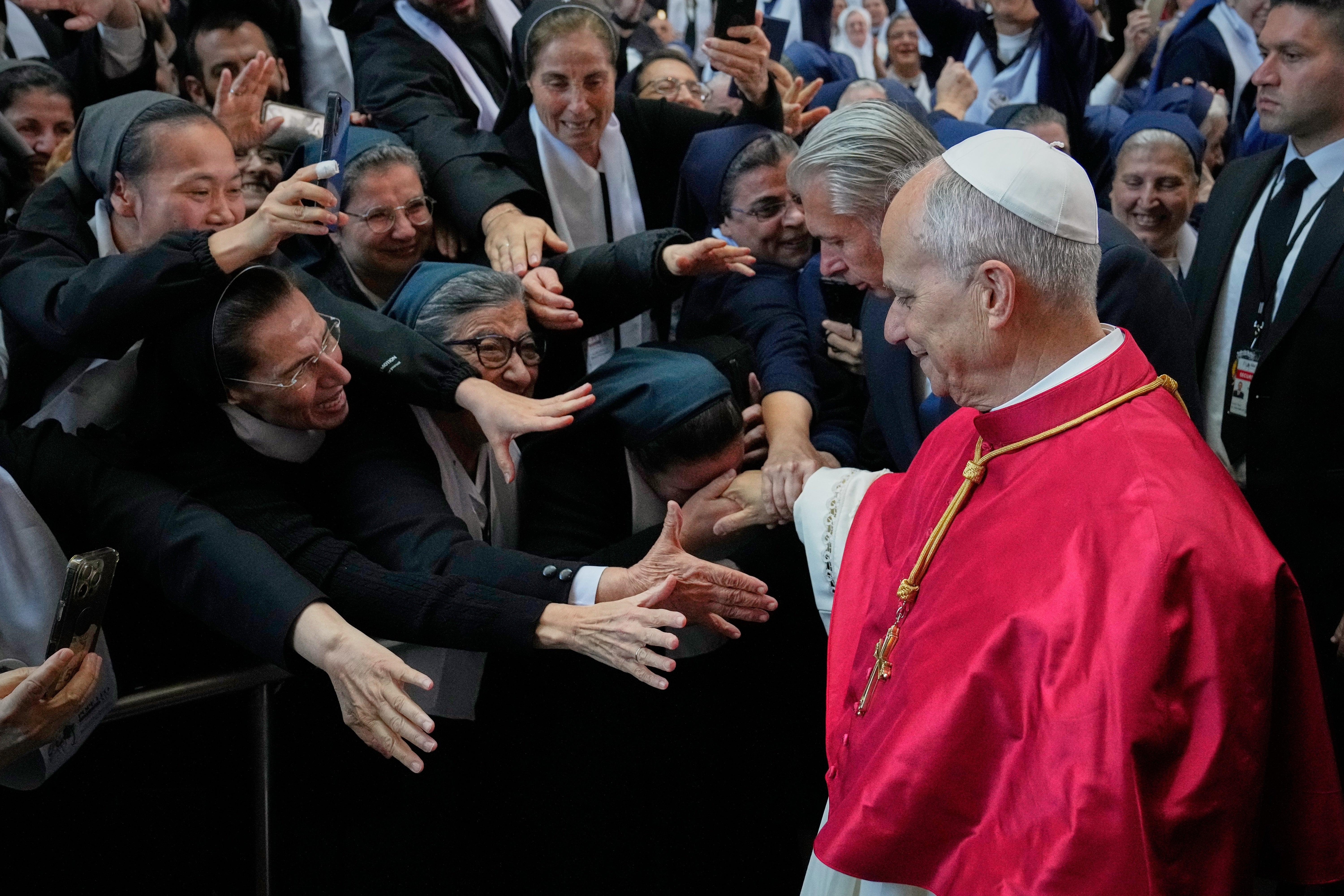 A group of nuns reach out to Pope Leo XIV as he arrives at the Catholic basilica of Harissa, Lebanon